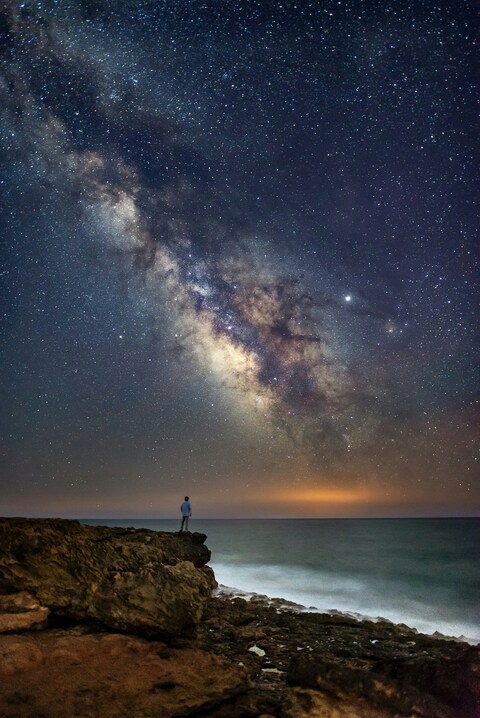 Man Gazing at Milky Way Above Coastal Sea