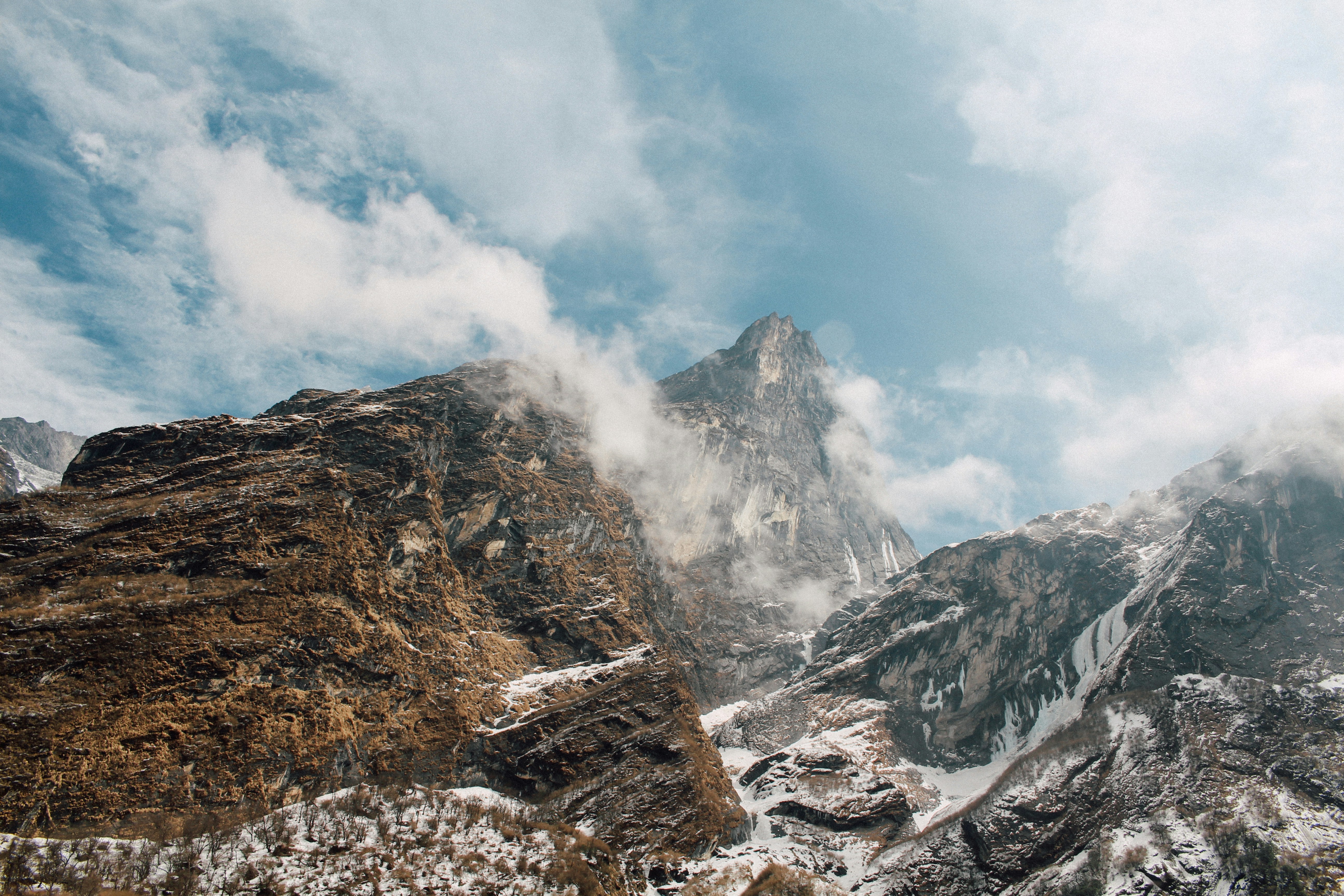 Snowy Mountain Peaks Under Cloudy Sky