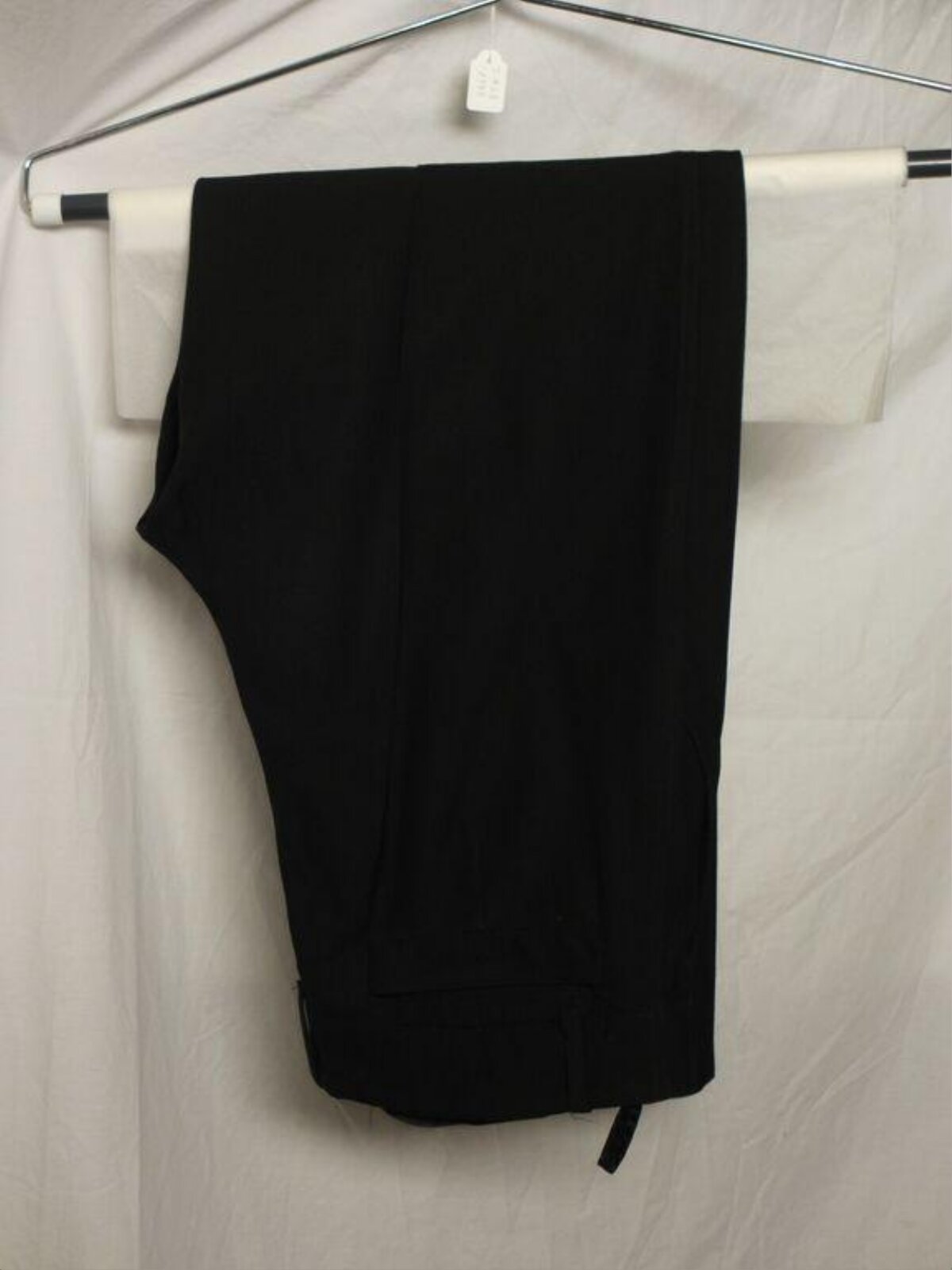 Folded Black Trousers Hanging on Rack
