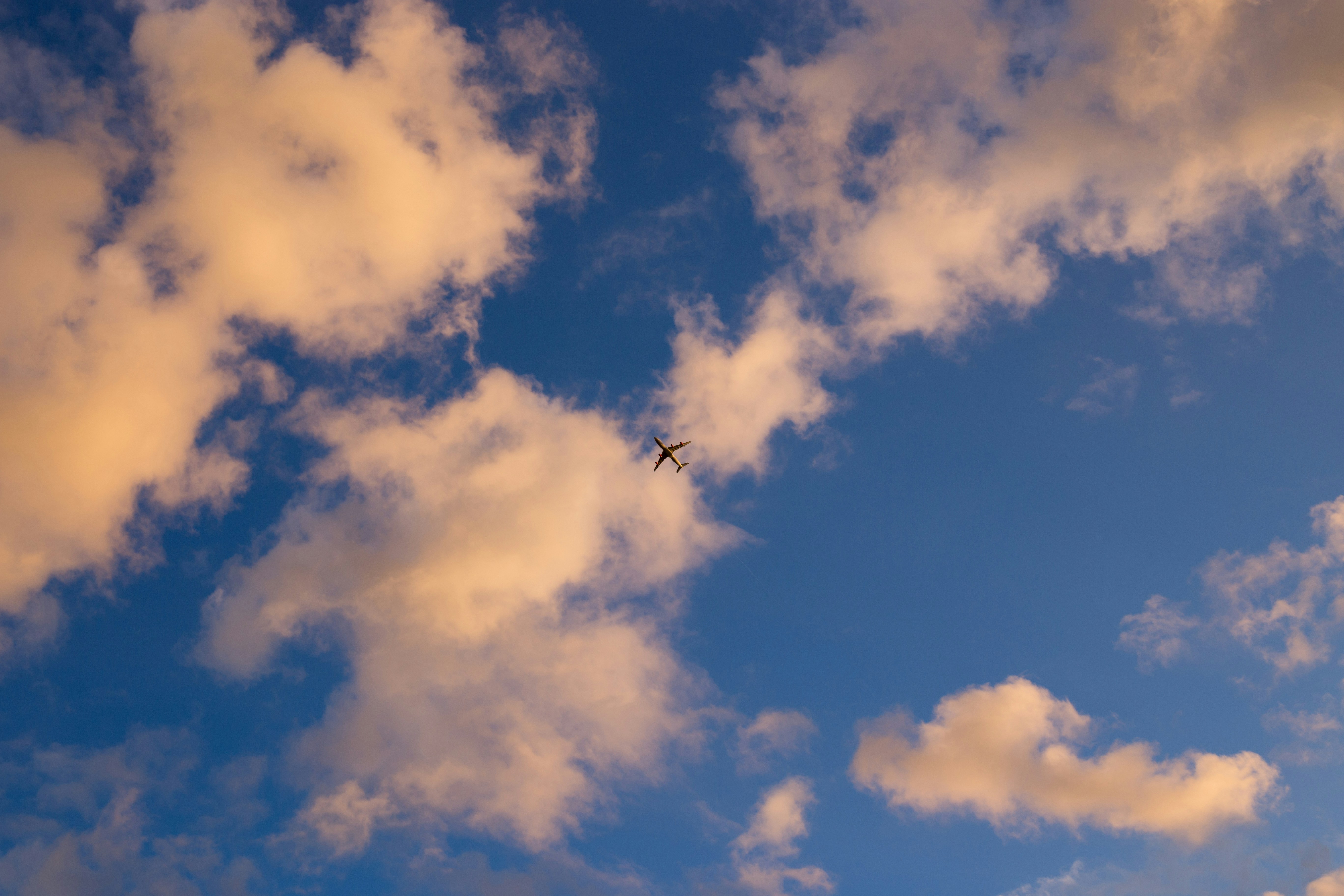 Airplane Flying Through Sunset Sky