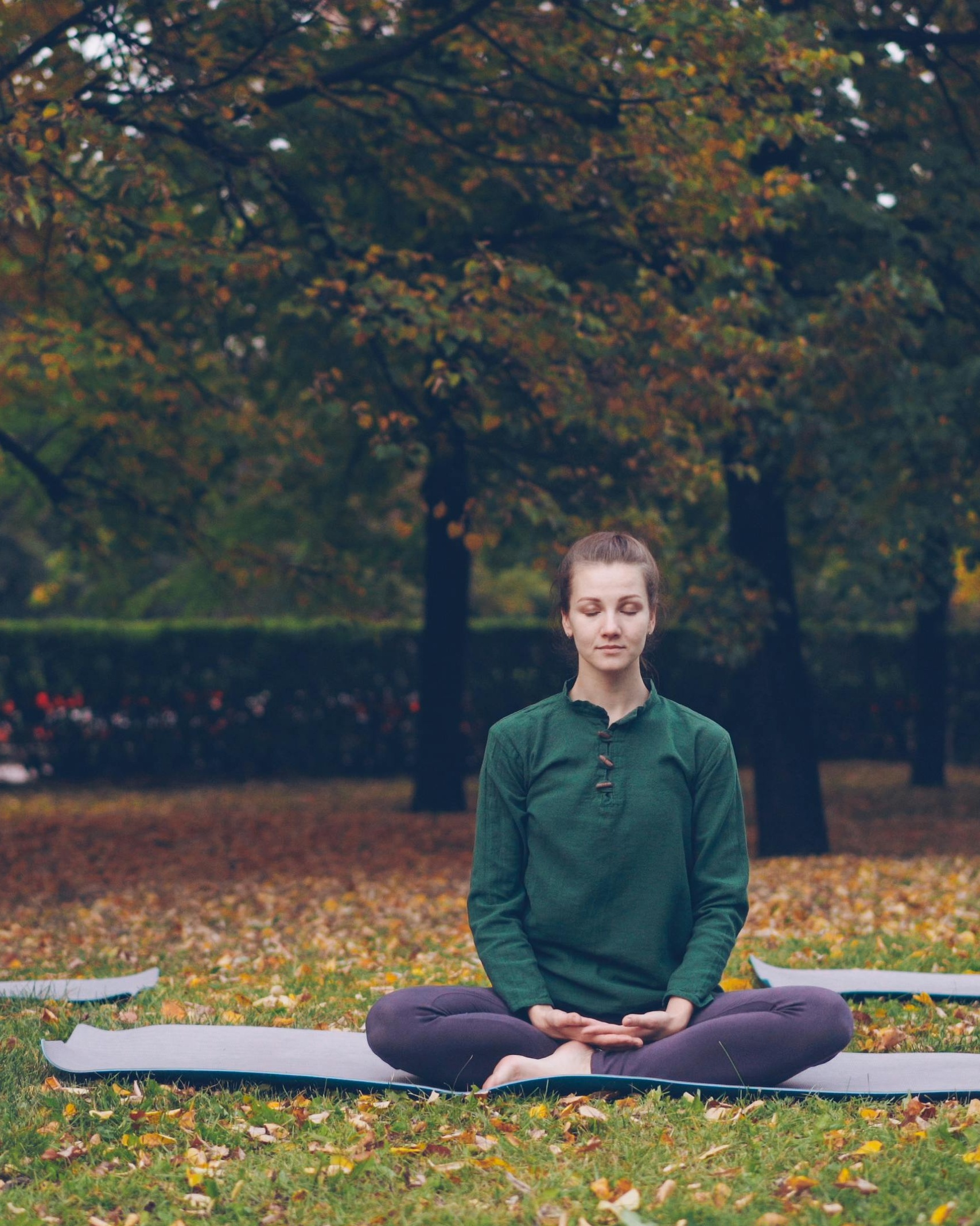 Woman Meditating in Autumn Park