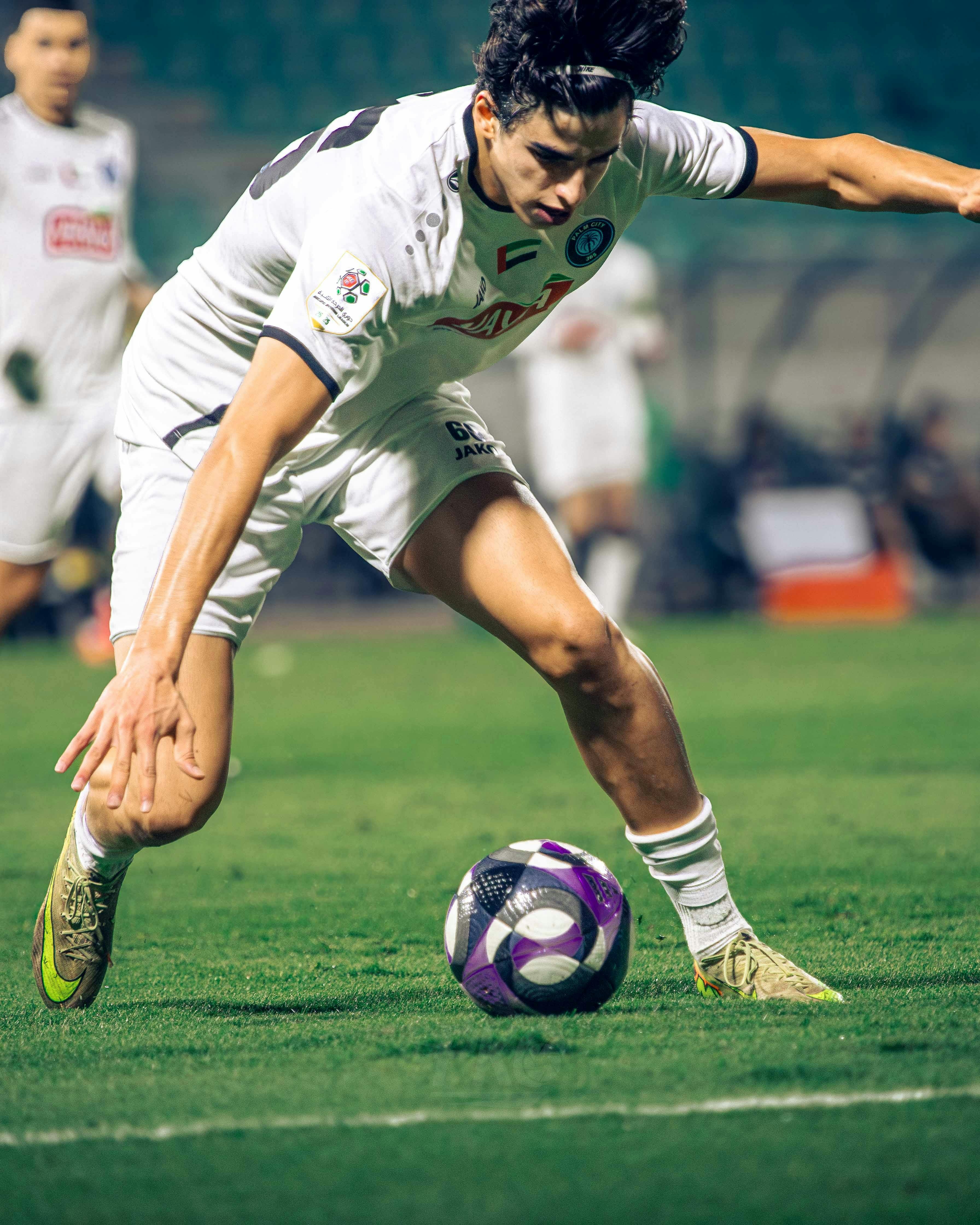 Soccer Player Dribbling on Football Field