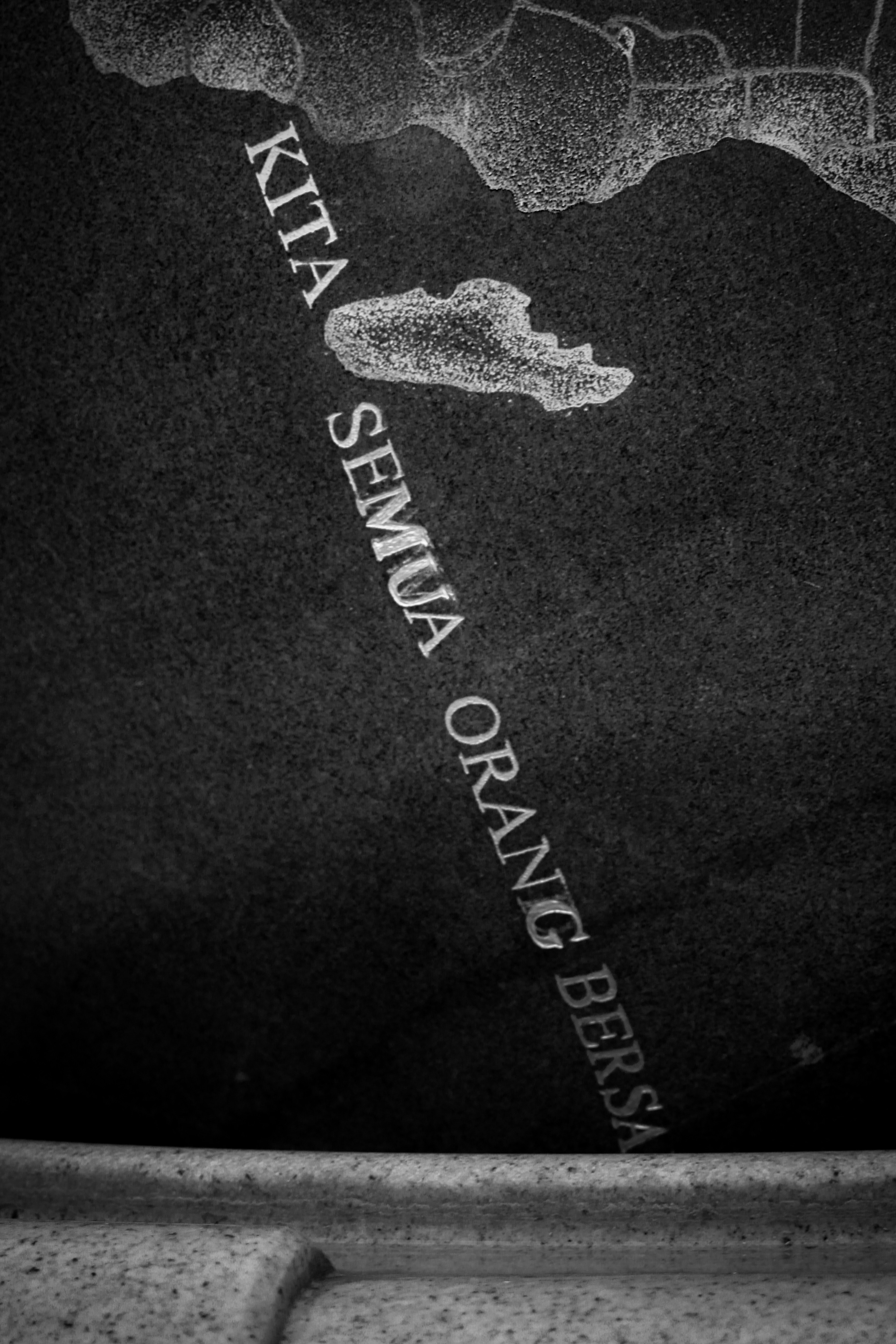 Engraved Indonesian Text on Stone Monument