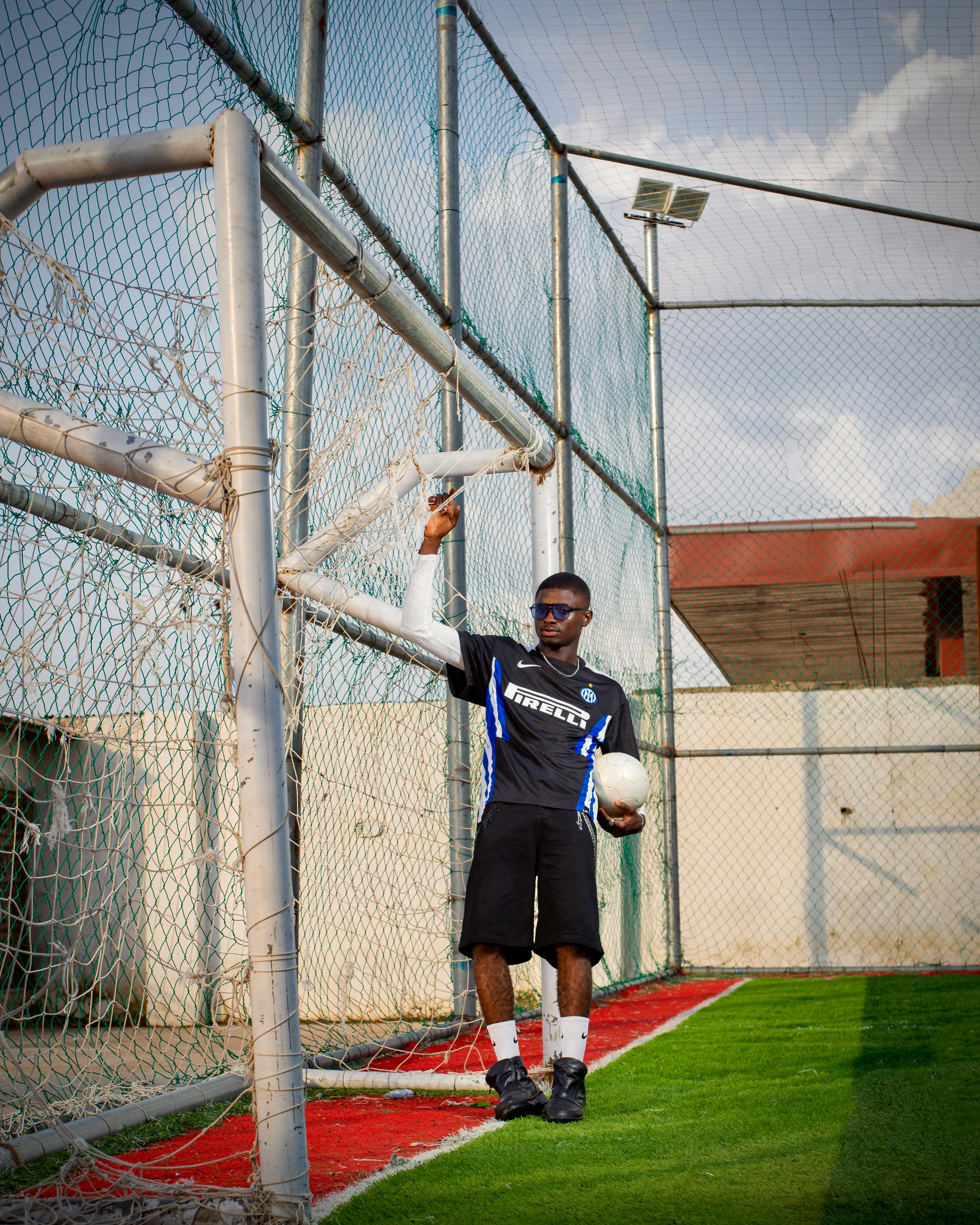 Man Holding Soccer Ball at Soccer Field