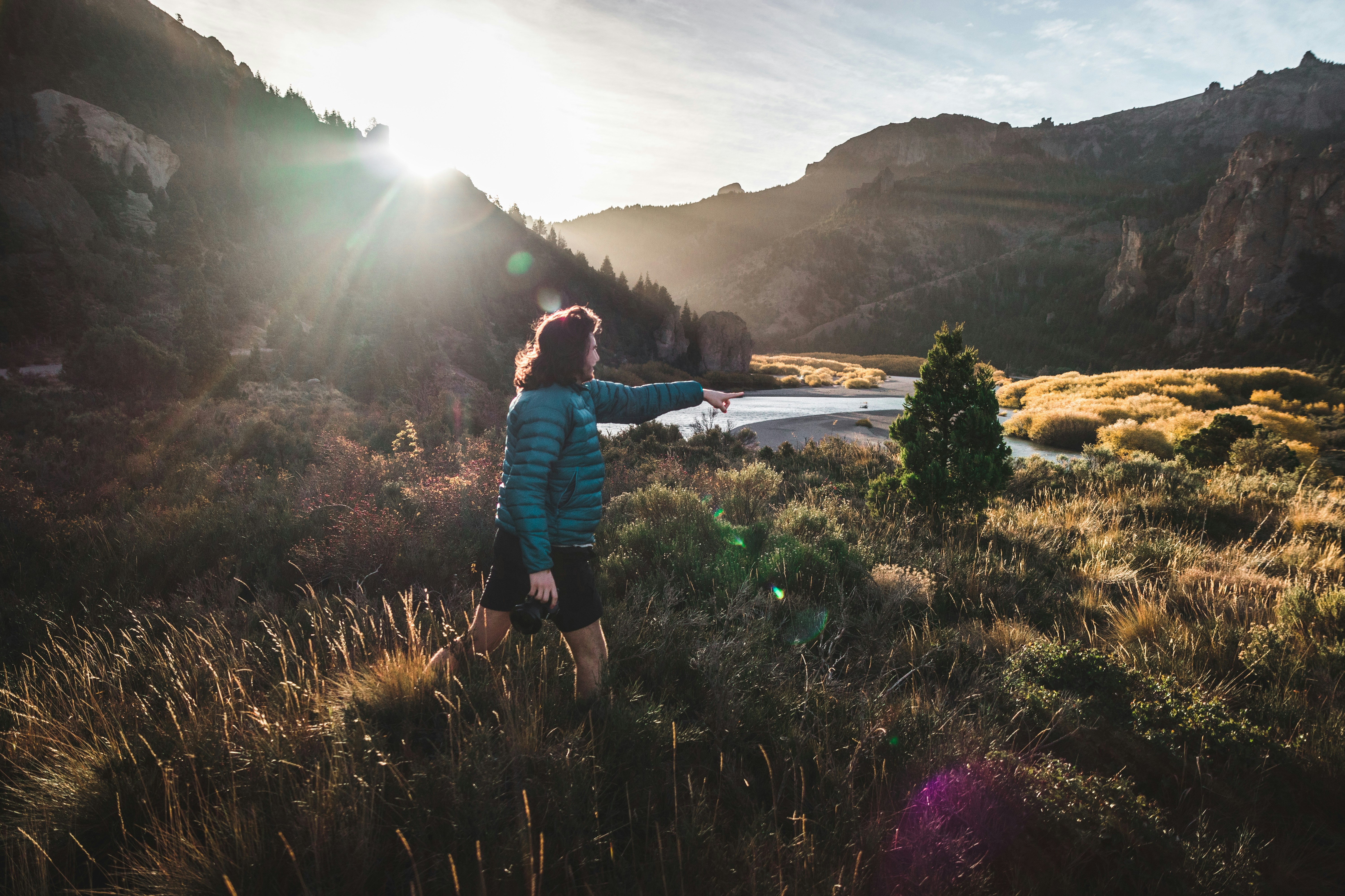 Hiker Points to River Valley at Sunrise