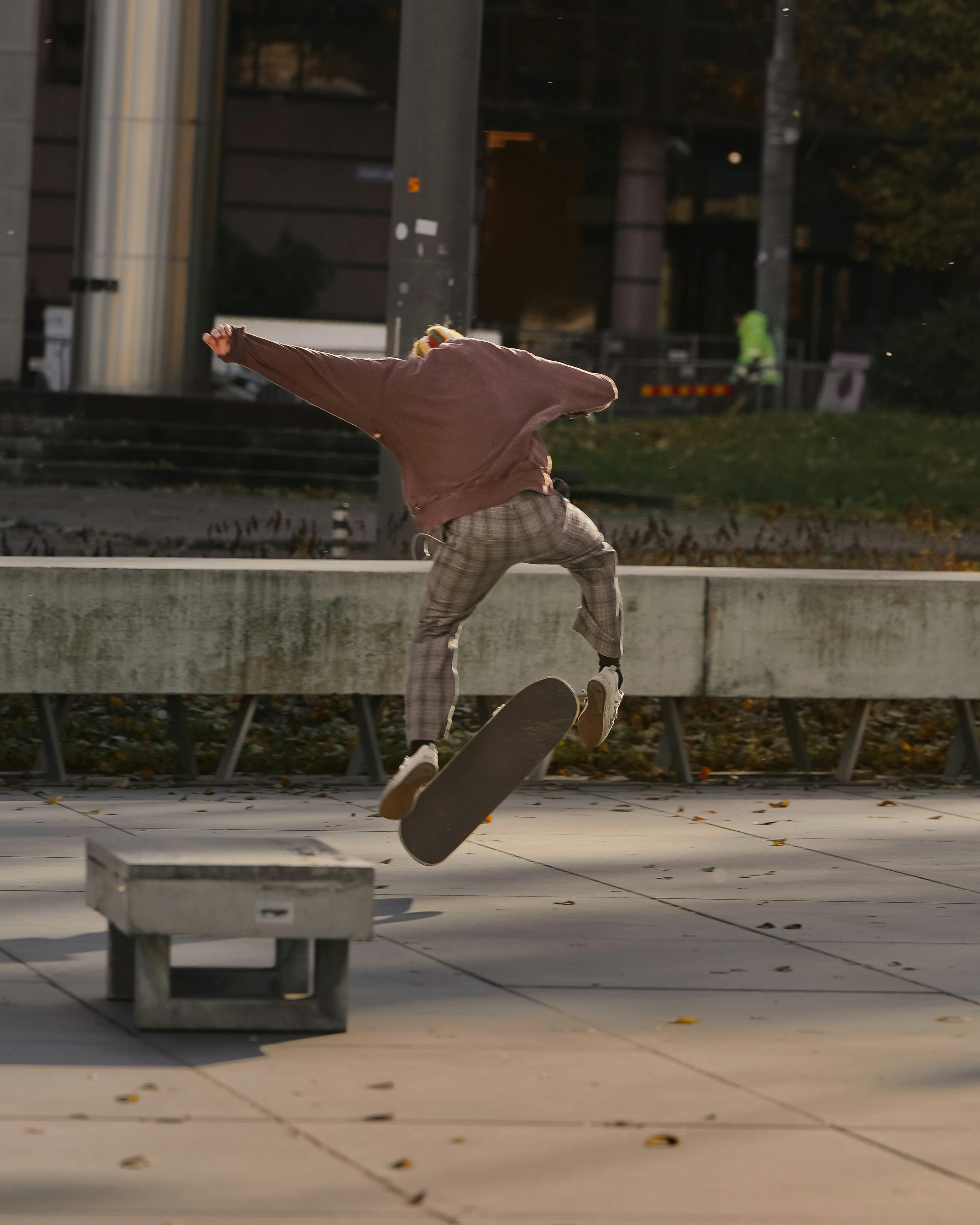 Skateboarder Performs Trick In Urban Plaza