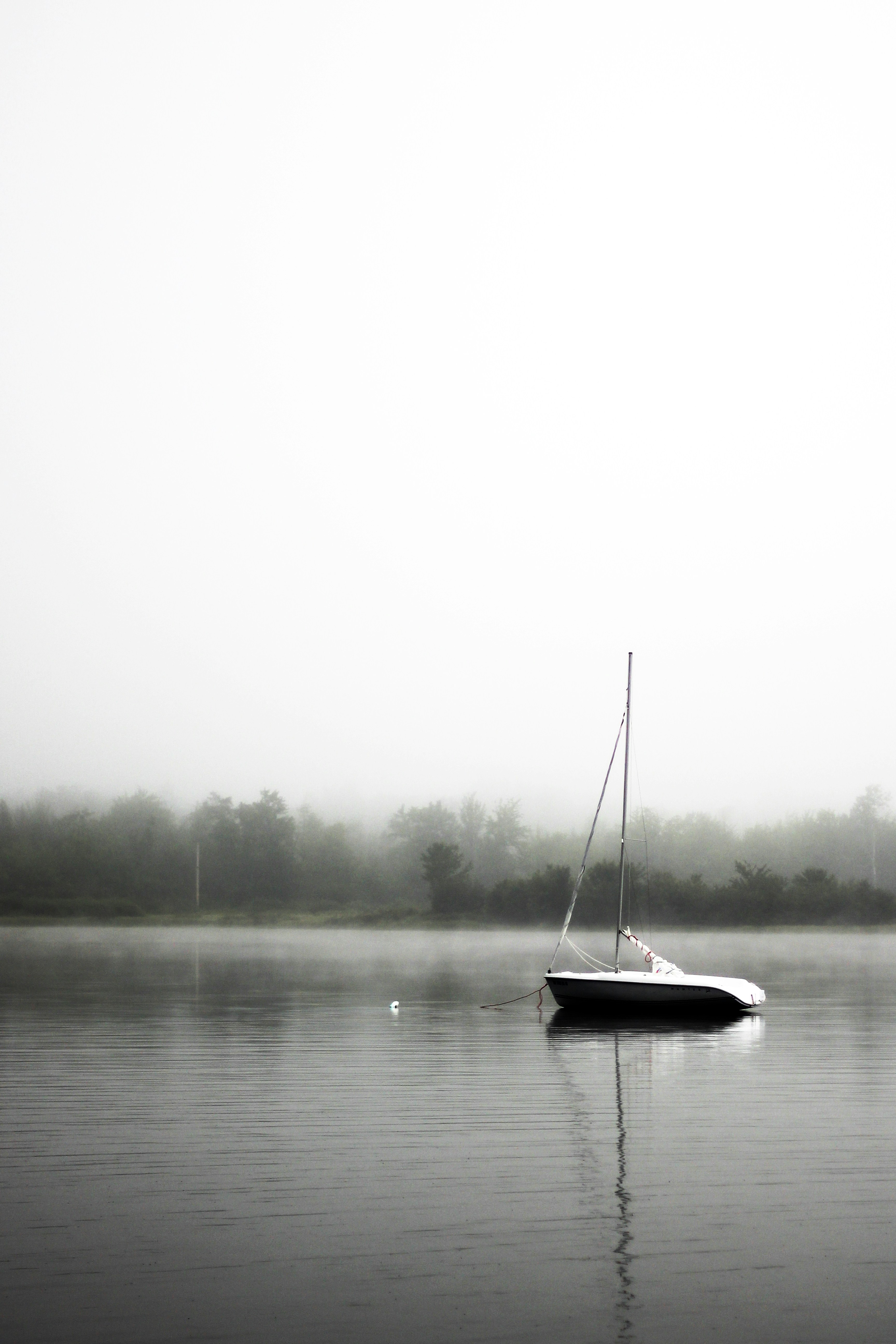 Sailboat Anchored on Foggy Lake