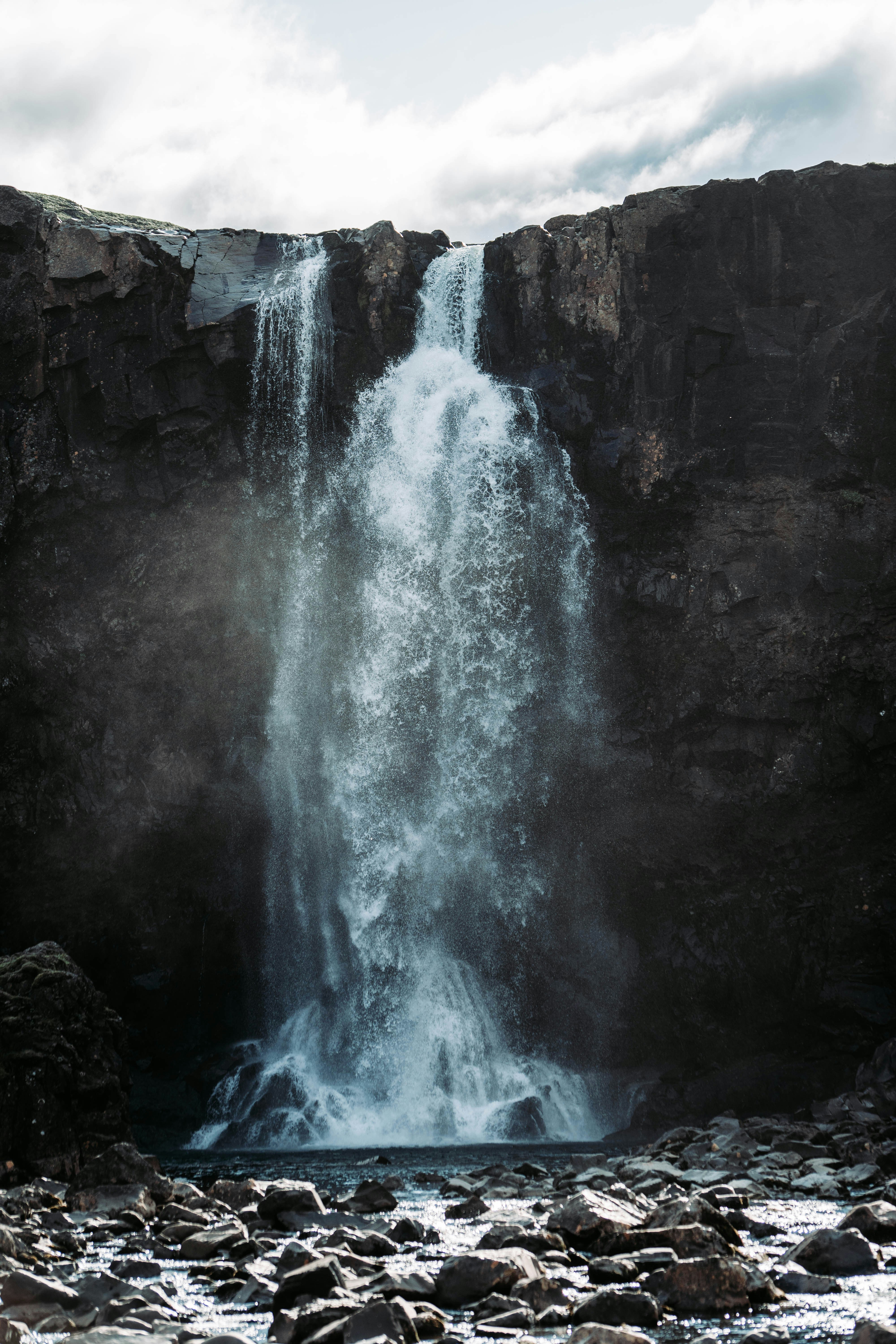 Double Waterfall on Dark Rocky Cliff