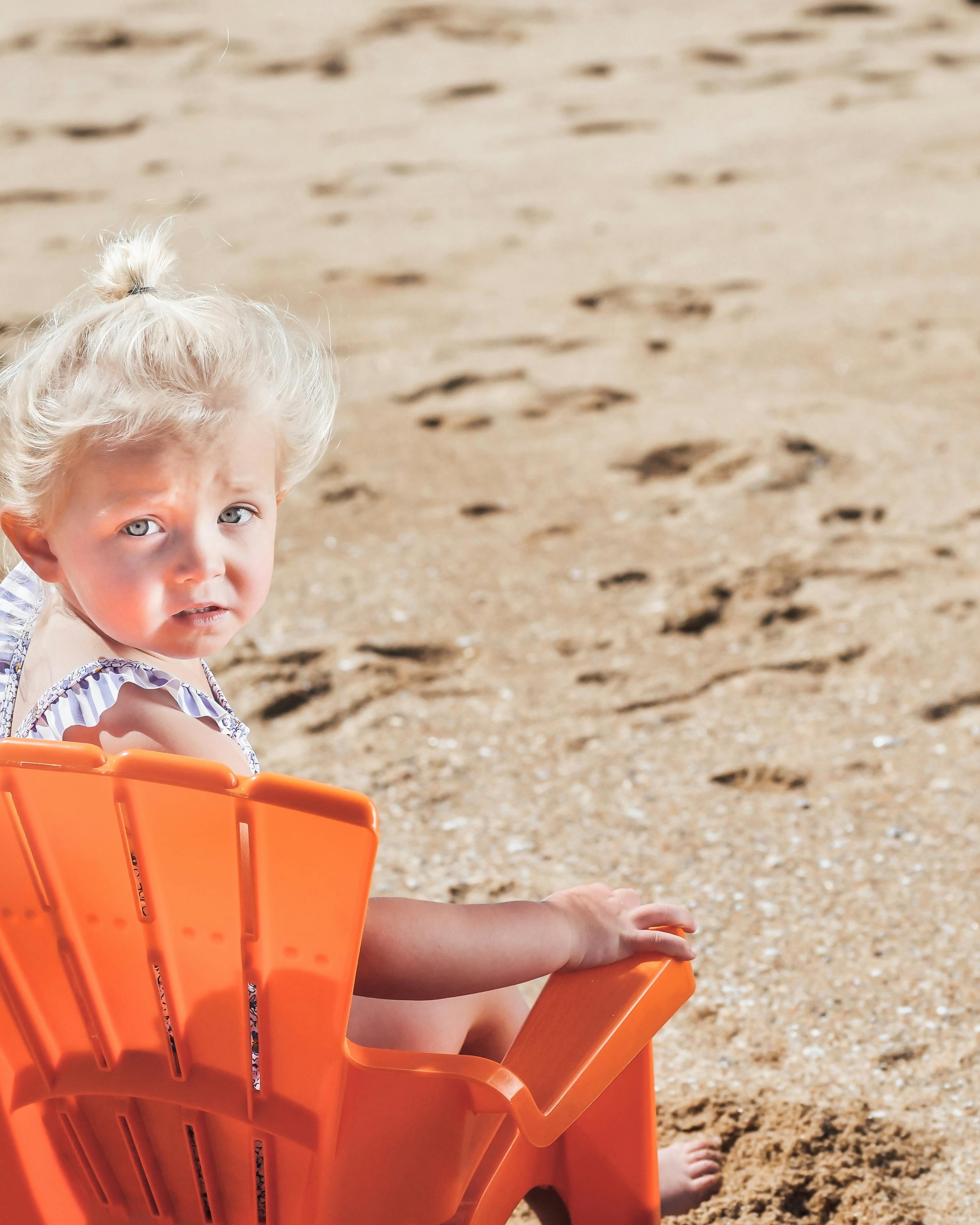 Toddler Girl Sitting At Sandy Beach