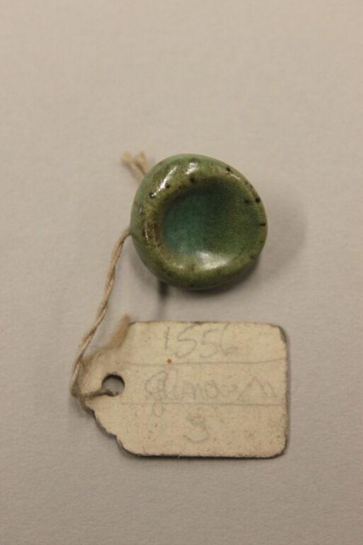 Green Glazed Ceramic Artifact With Tag