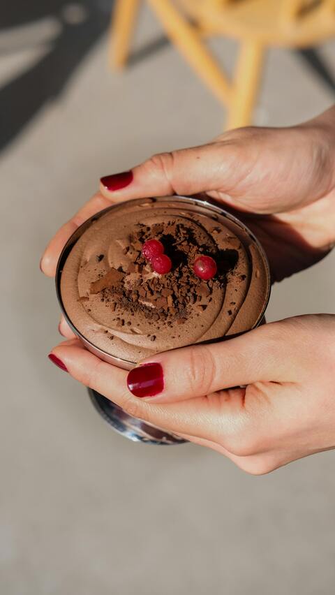 Garnished Chocolate Mousse Held By Hands