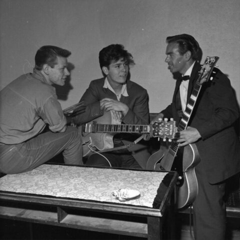 Three Musicians Chatting With Guitars