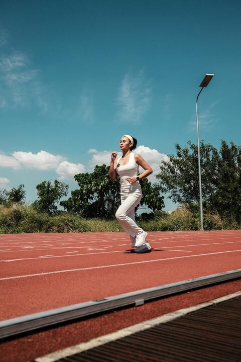 Woman Jogging on Outdoor Running Track