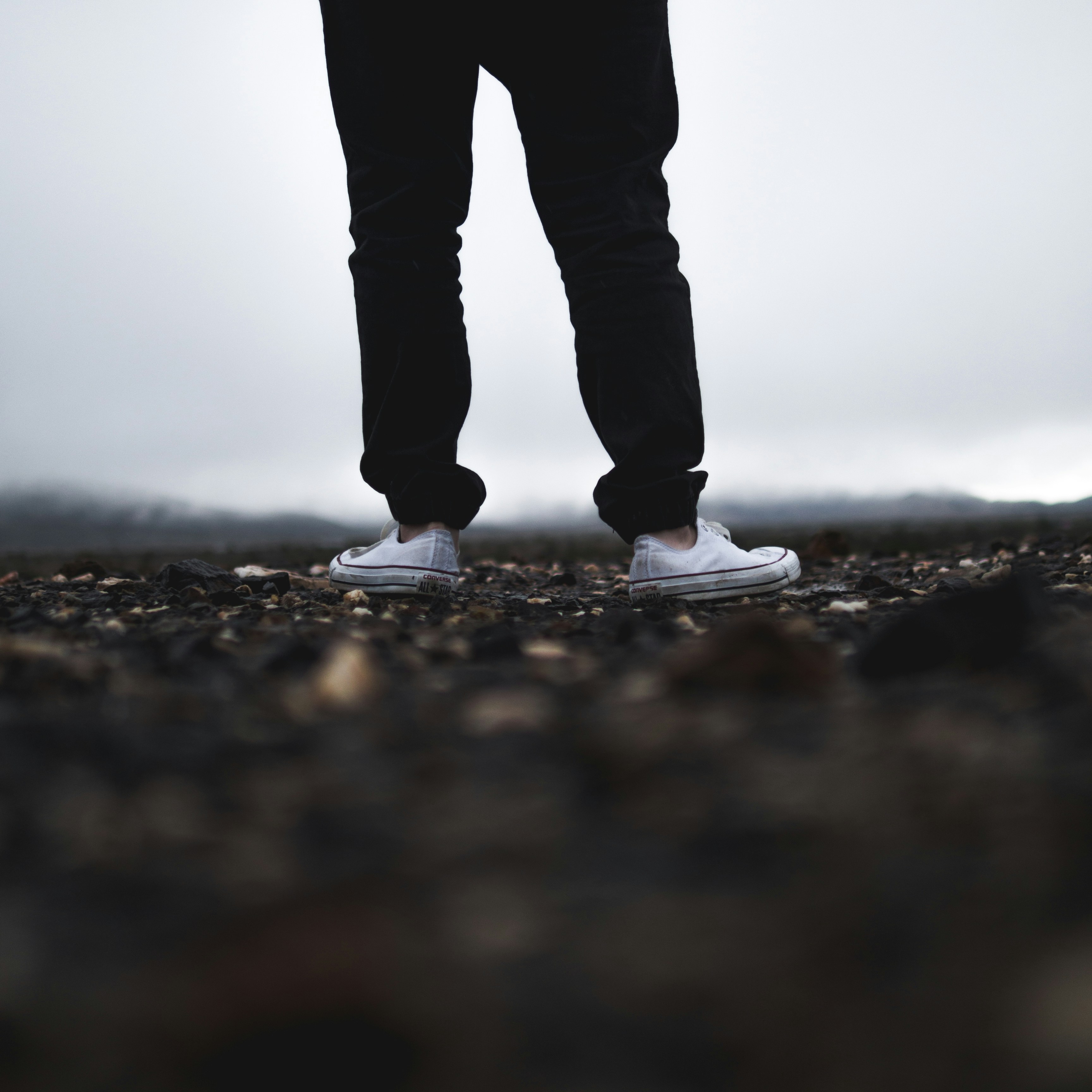 Person Standing on Gravel in Fog