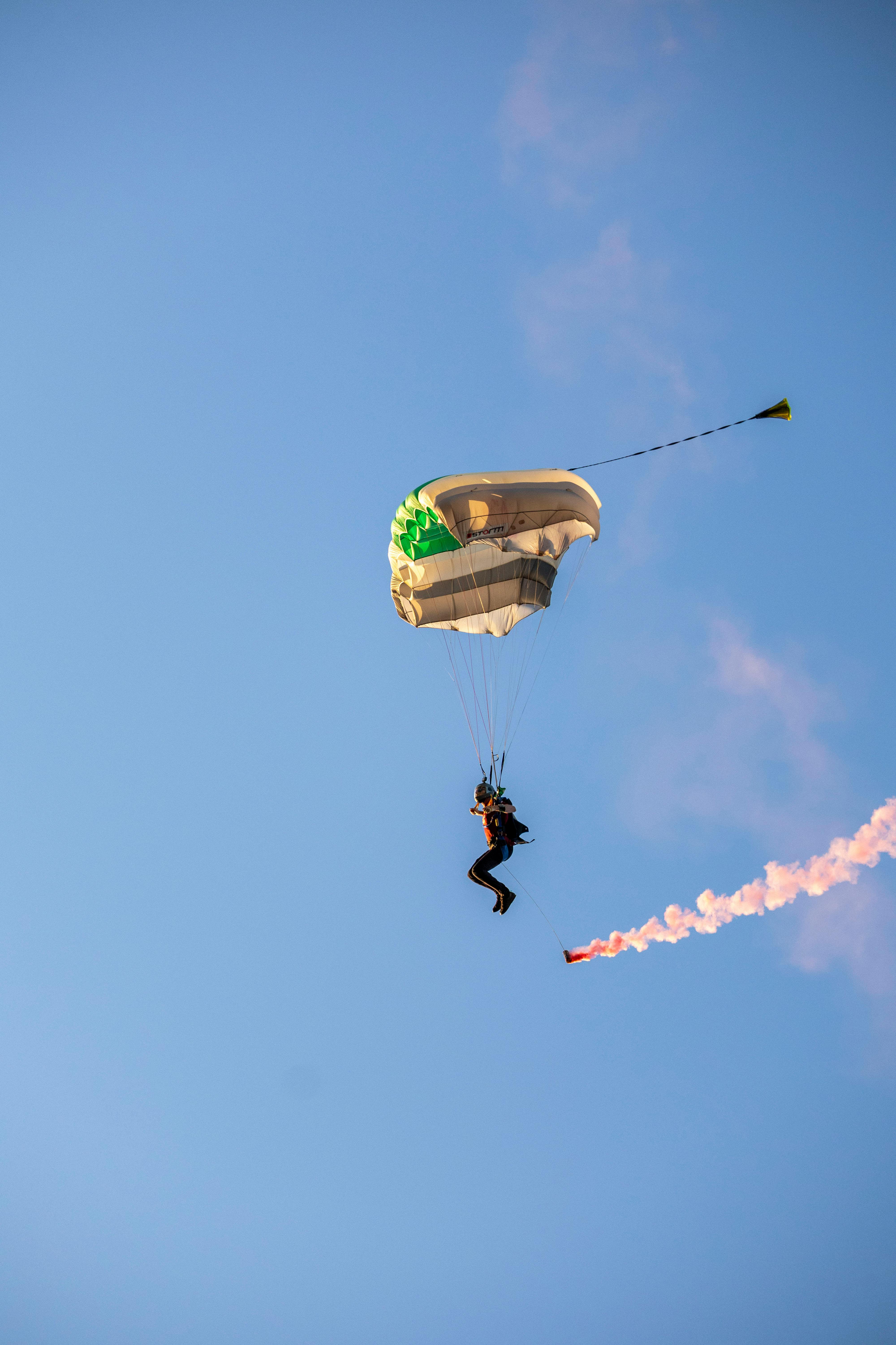 Skydiver Parachuting with Smoke Trail