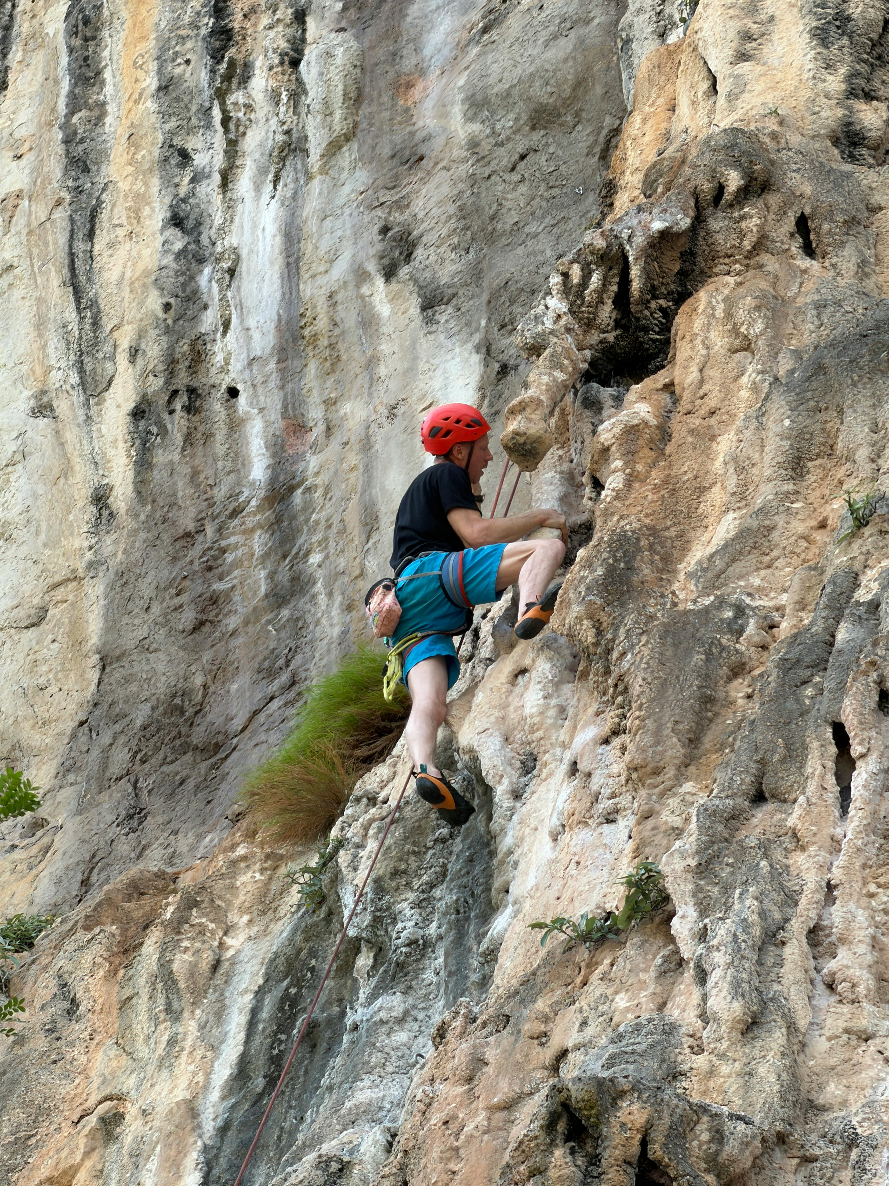 Rock Climber Ascending Limestone Cliff