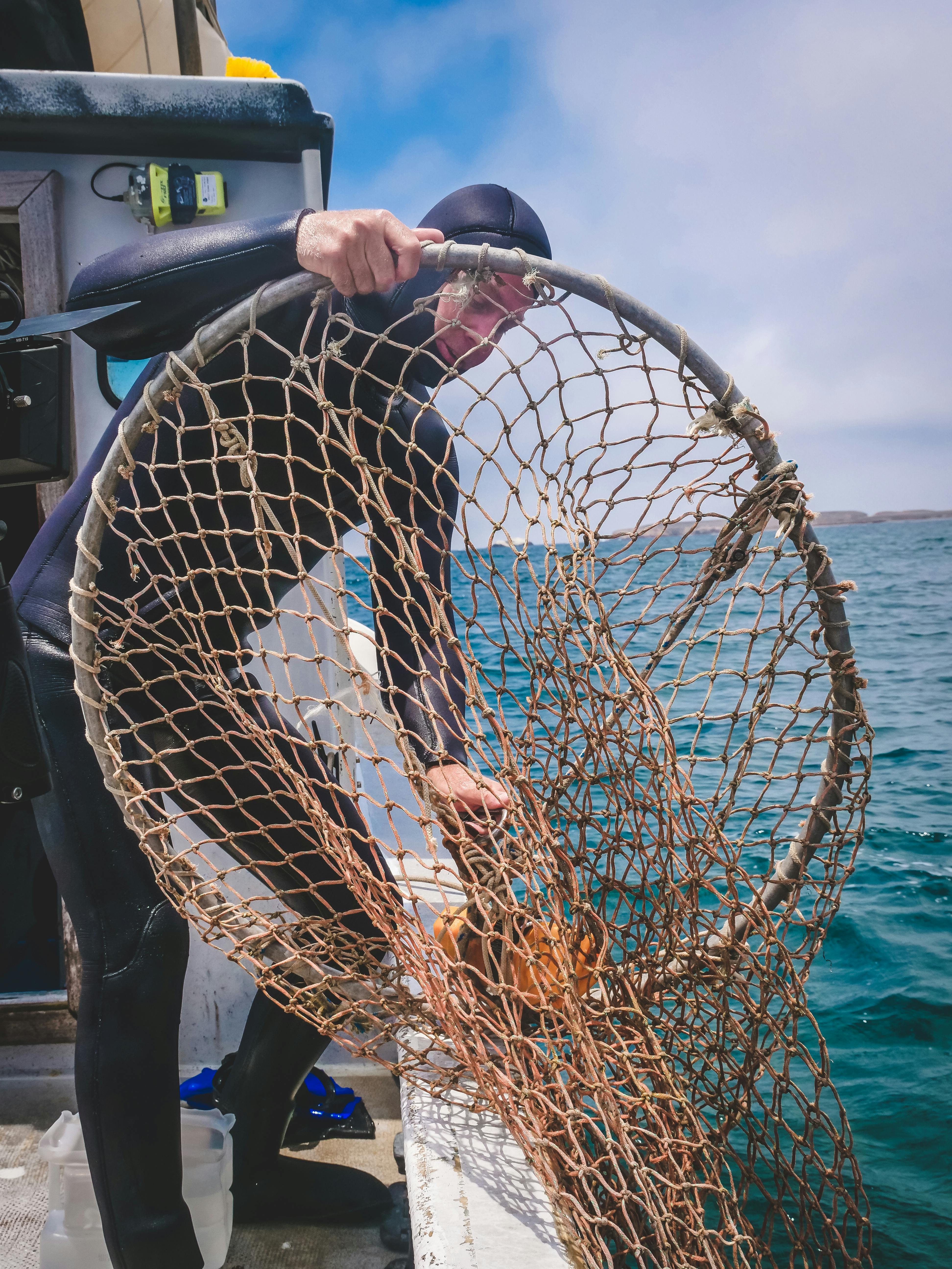 Fisherman Preparing Fishing Net on Boat