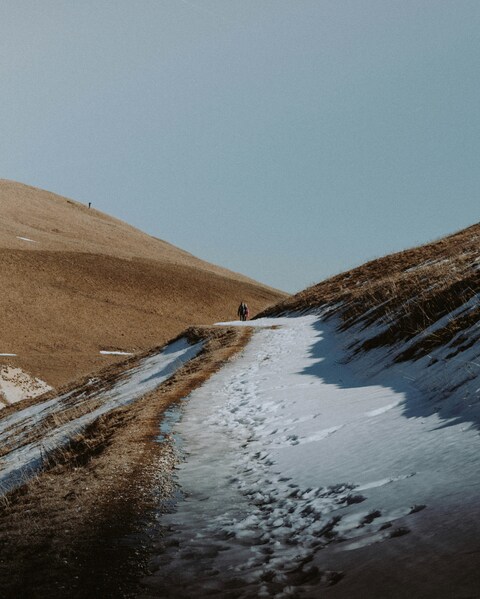 Hikers on Winter Hillside Path