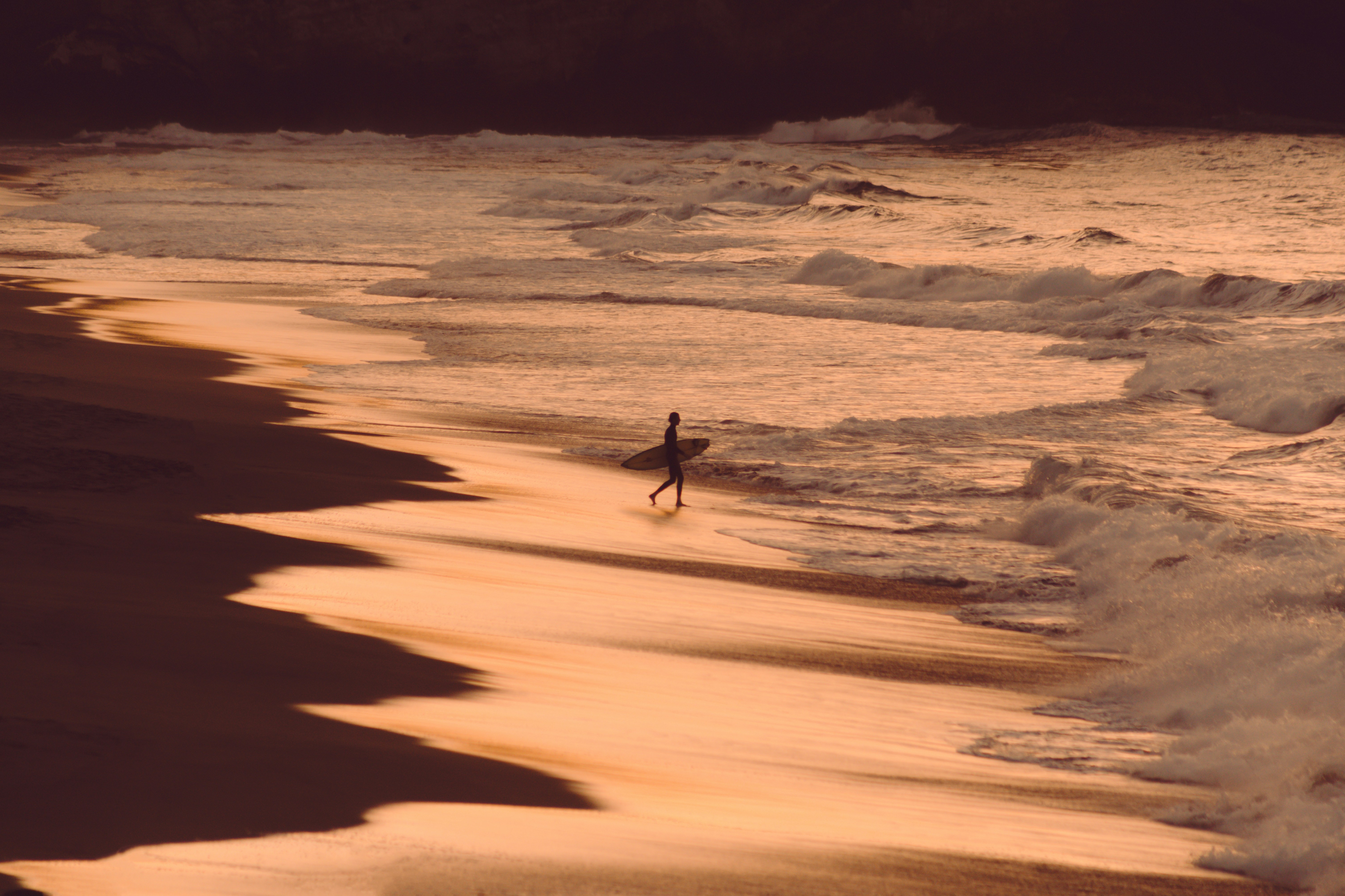 Surfer Walking on Sunset Beach
