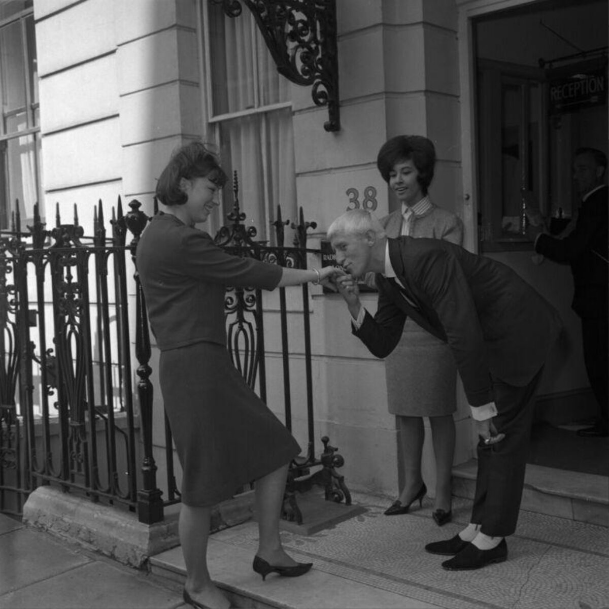 Man Kissing Woman's Hand Outside Building