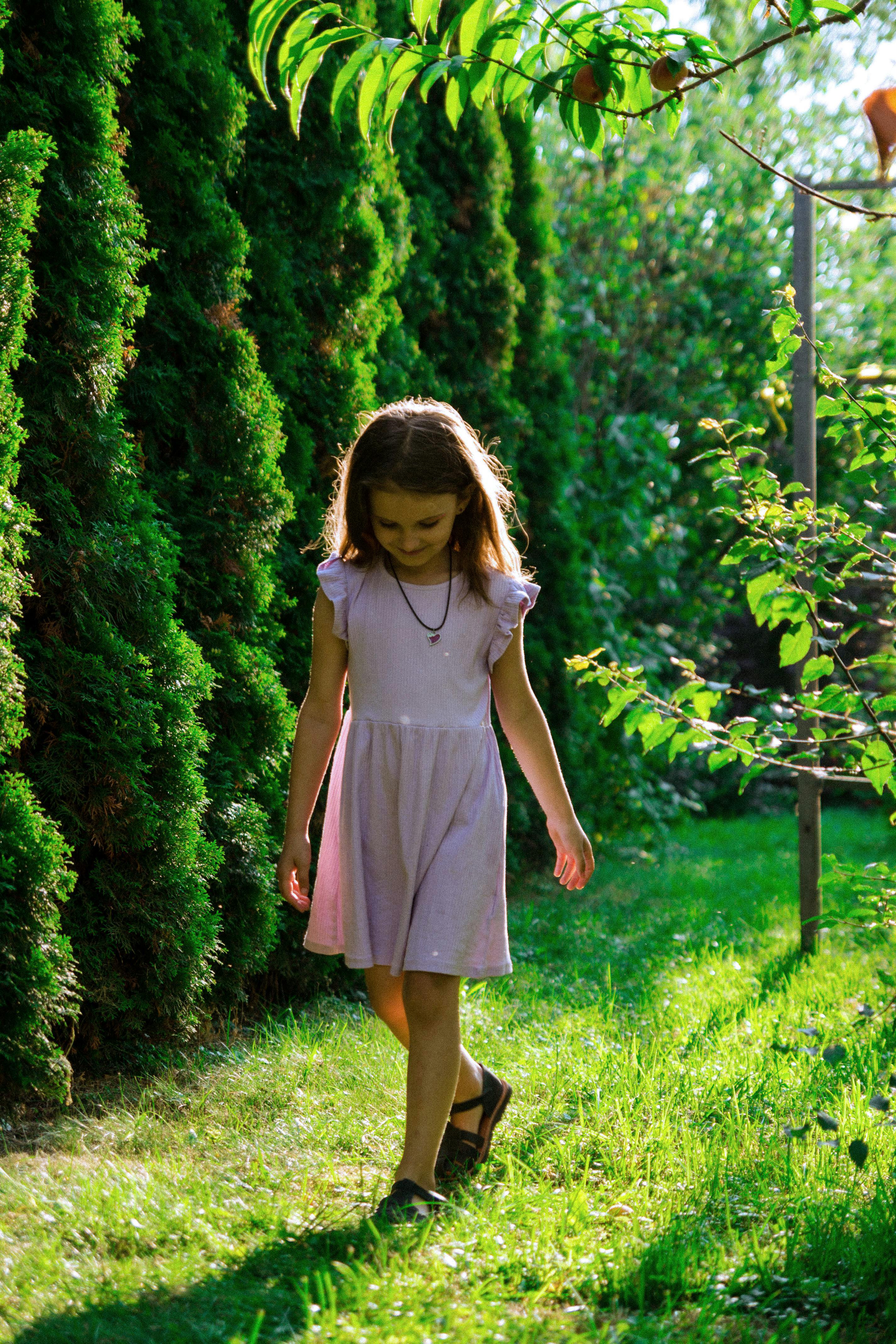 Girl Walking in a Summer Garden