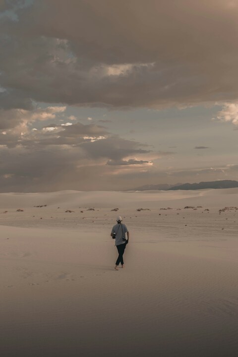 Man Walking on White Sand Dunes