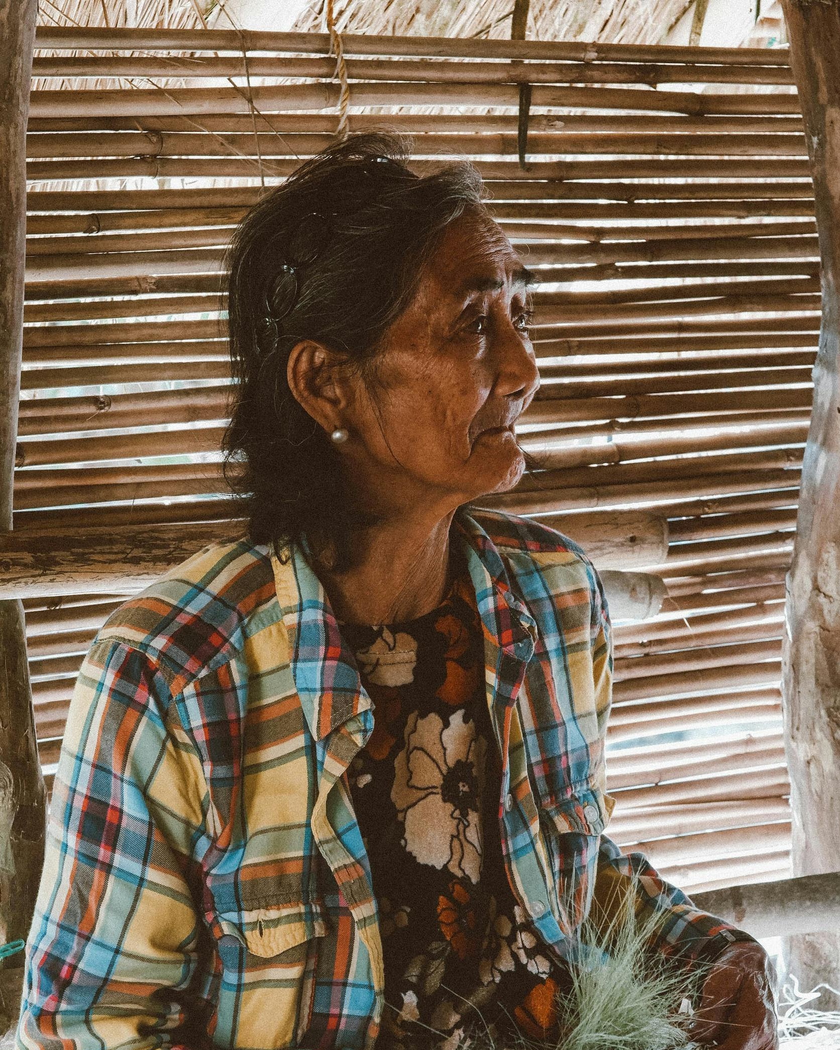 Elderly Woman in Bamboo Hut