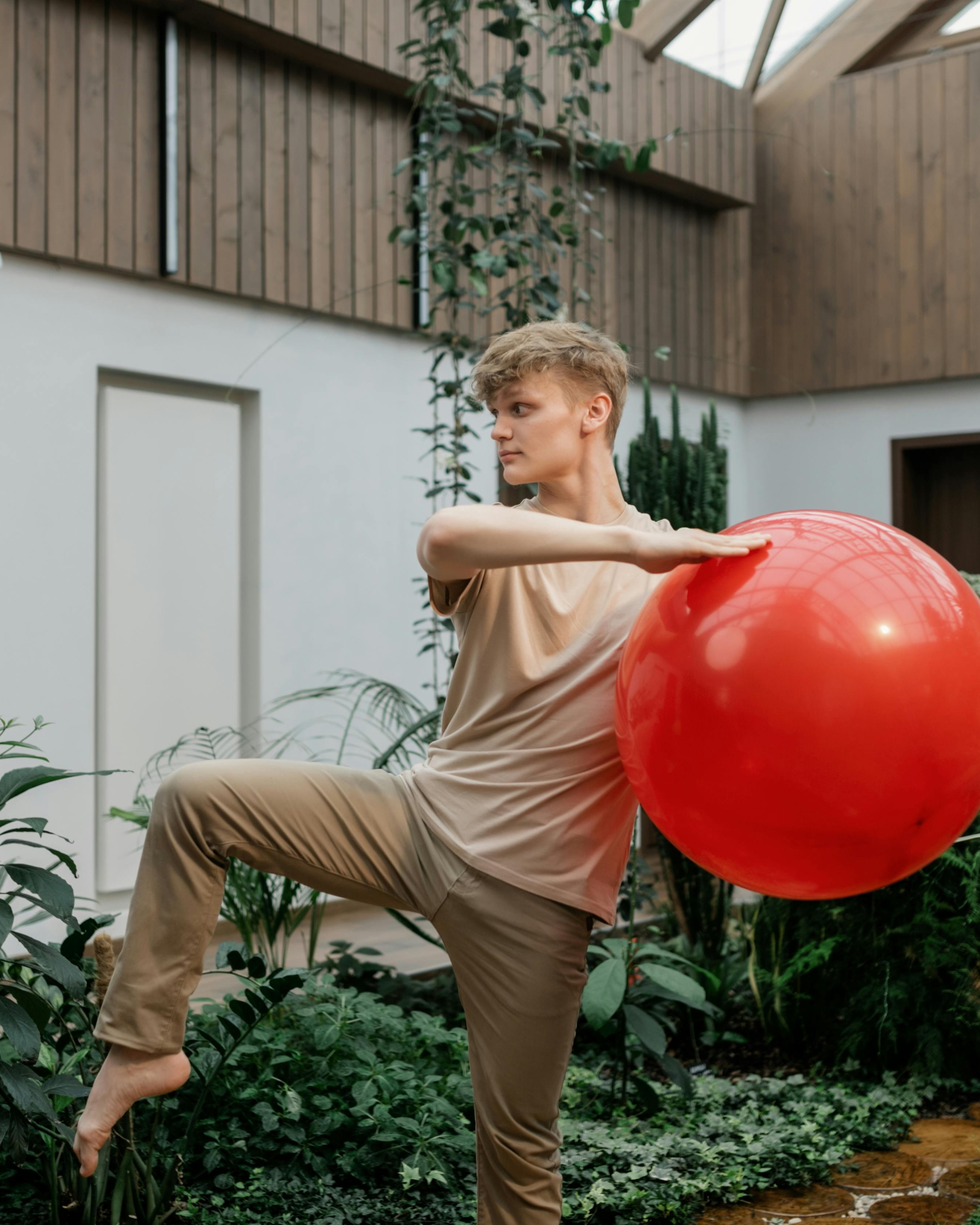 Young Man Stretching With Red Exercise Ball