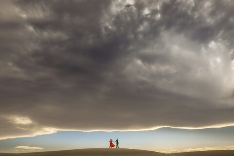 Couple Walking on Desert Dune