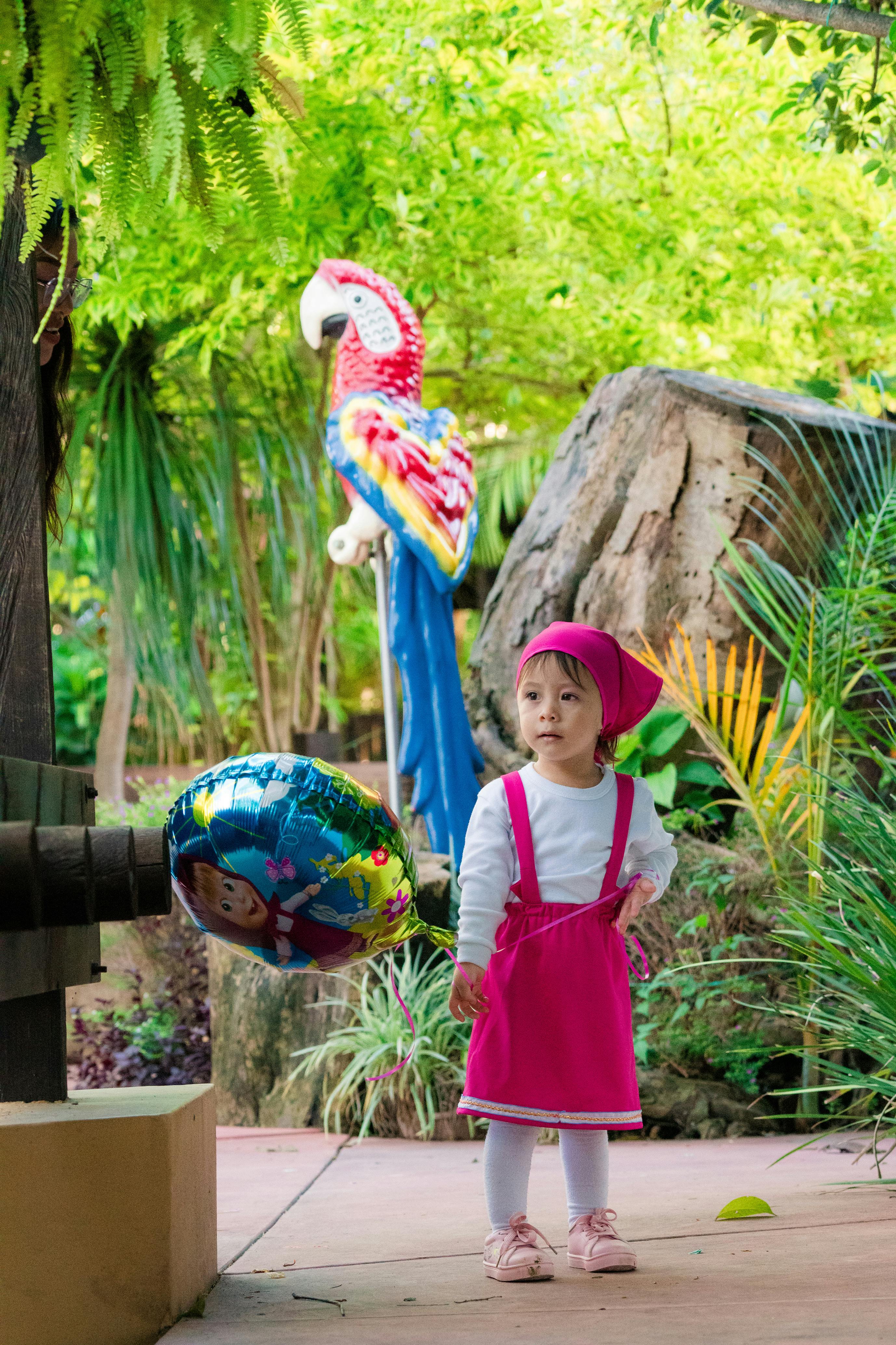 Little Girl With Balloon In Lush Garden