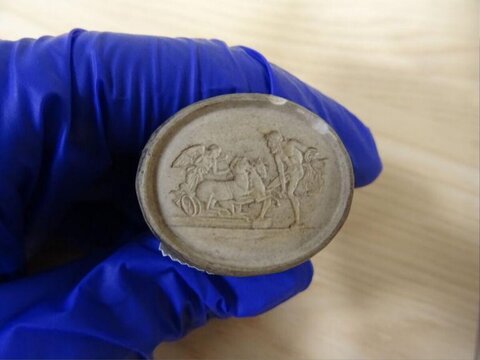 Ancient Carved Plaster Medallion Held by Gloved Hand