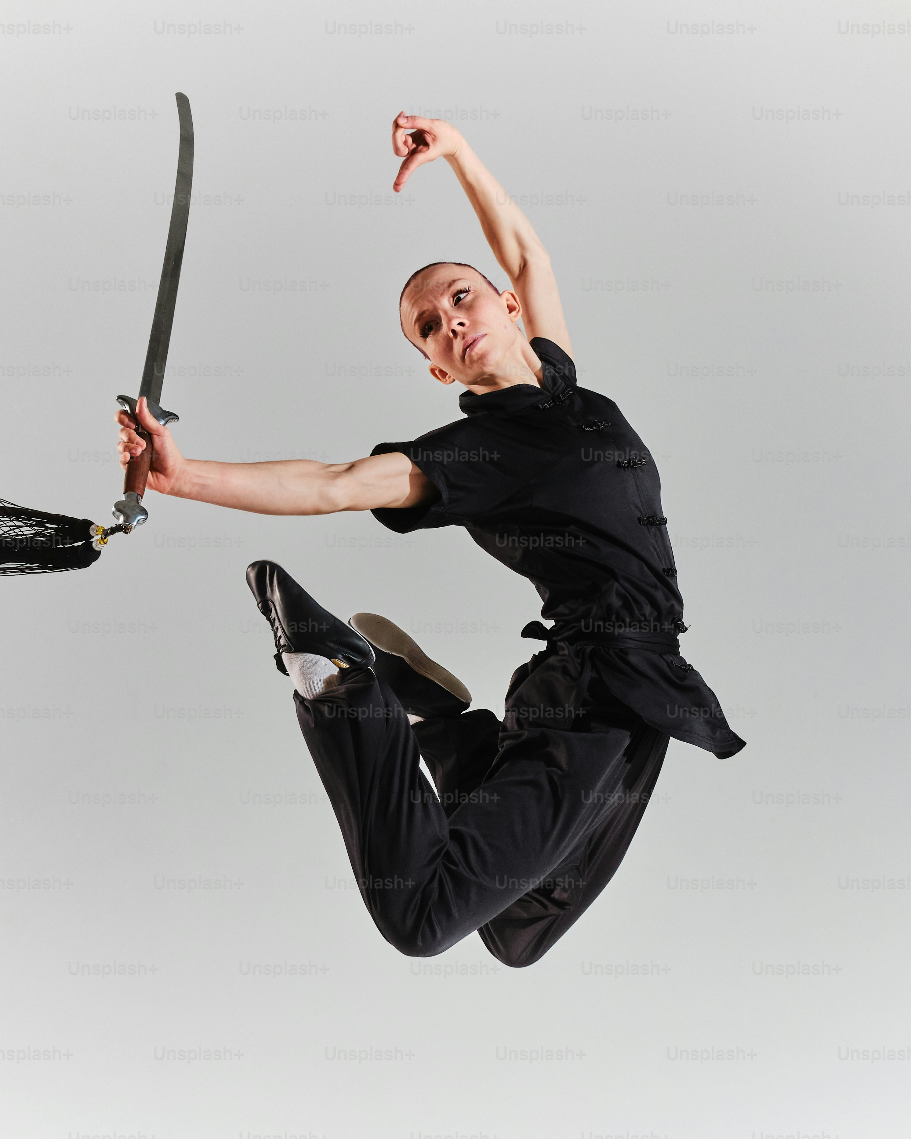 Female Martial Artist Jumping With Sword