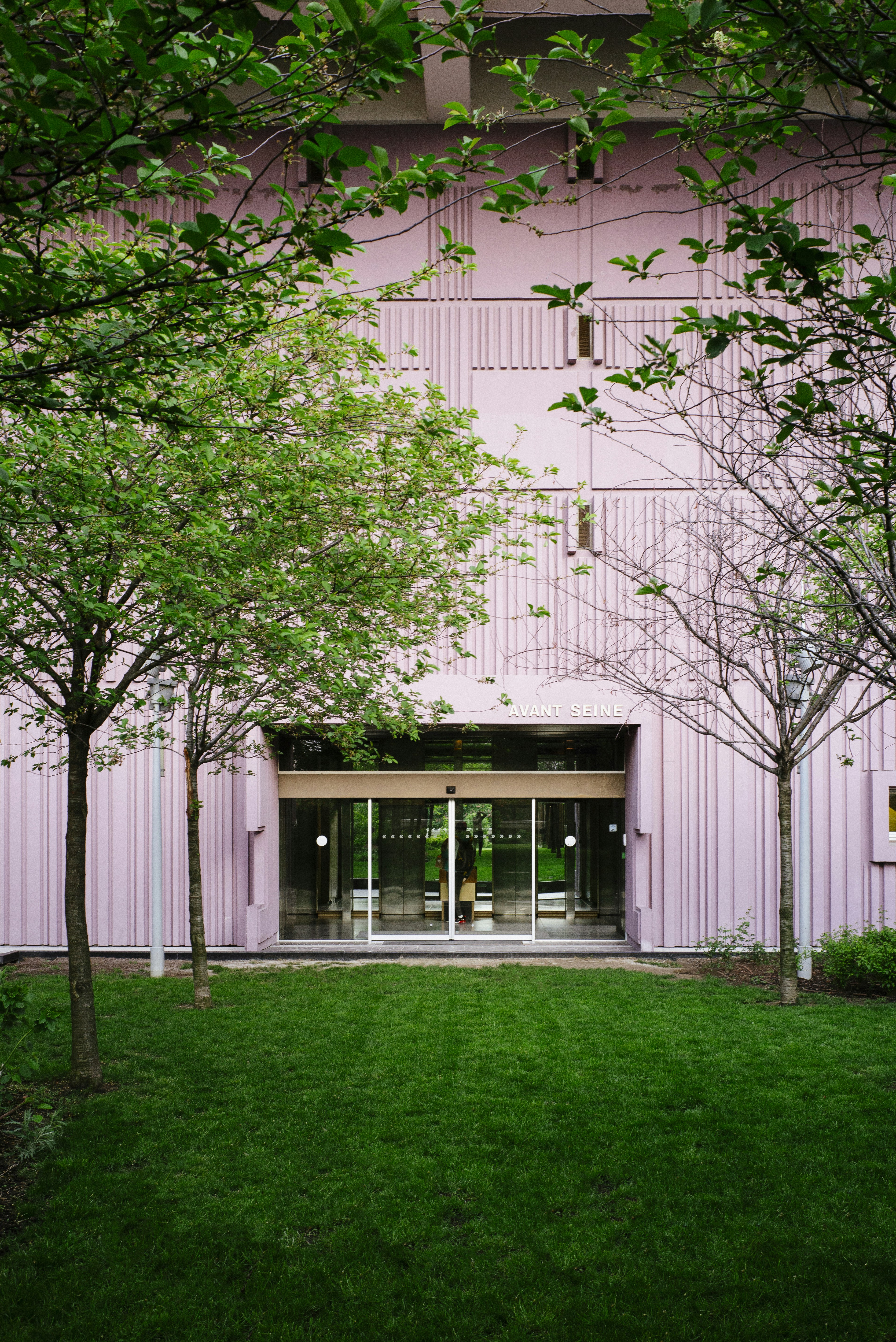 Pink Building Entrance With Green Lawn