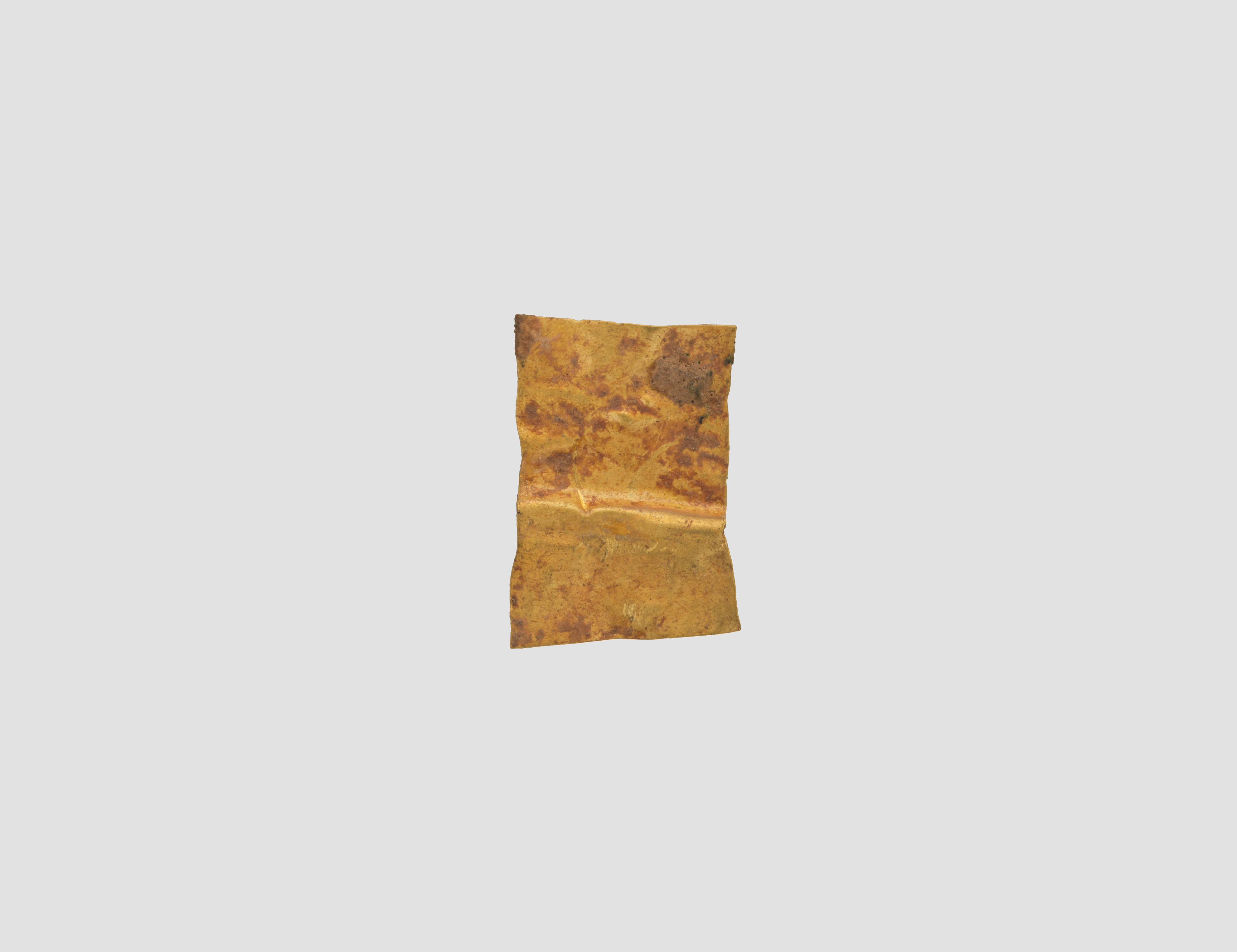 Aged Gold Foil Fragment on Gray Background