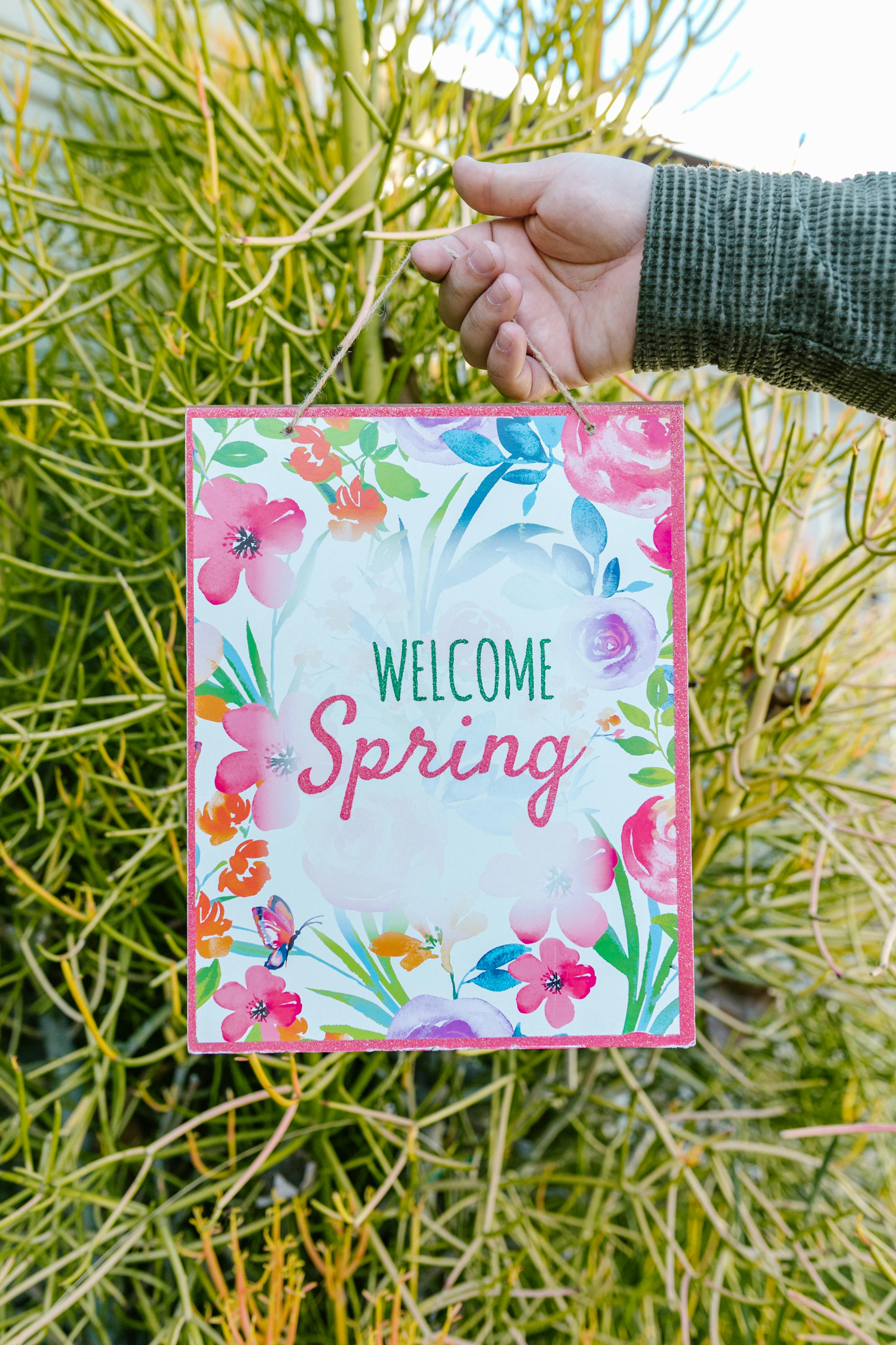 Hand Holding Welcome Spring Sign