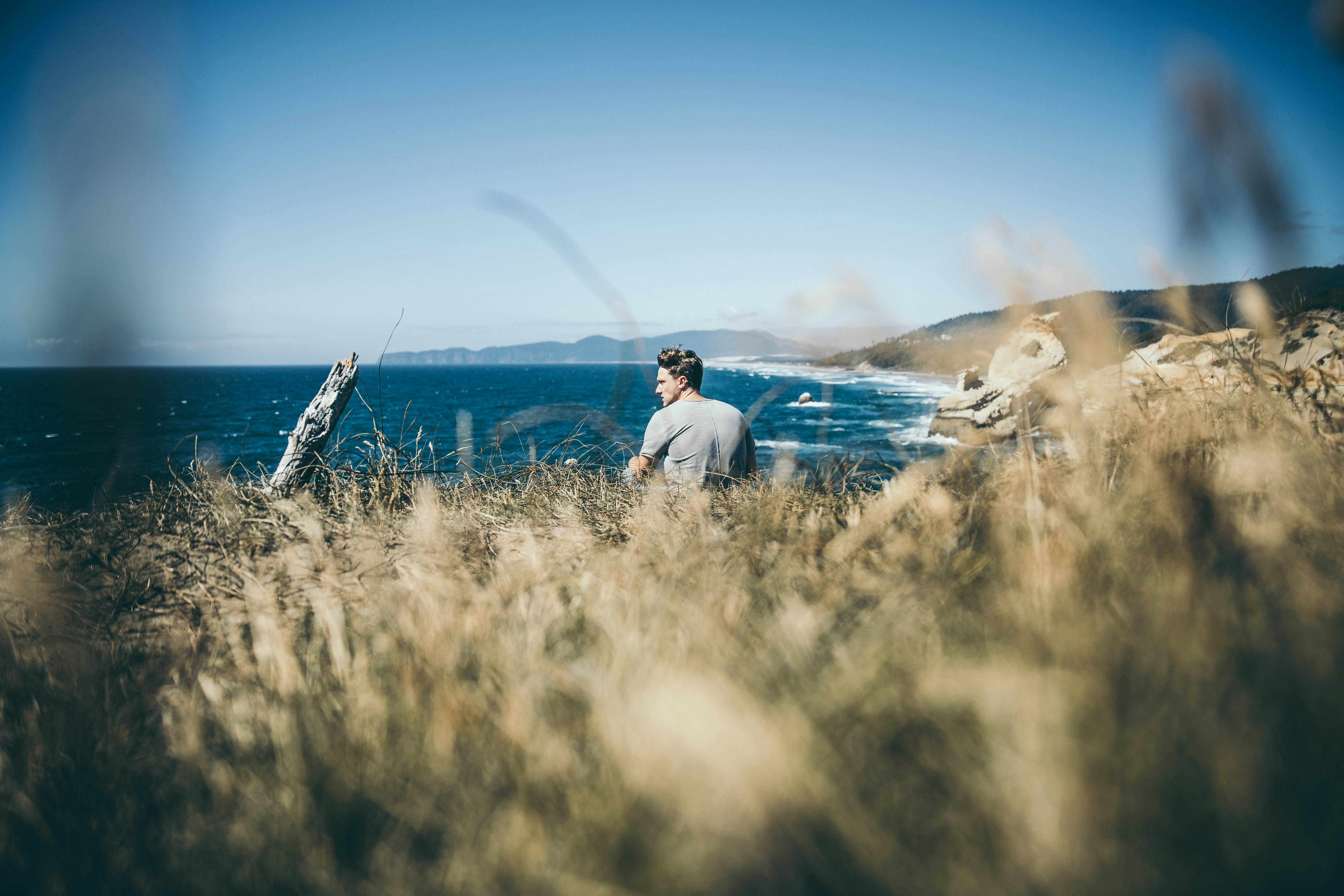Man Overlooking Ocean from Coastal Bluff