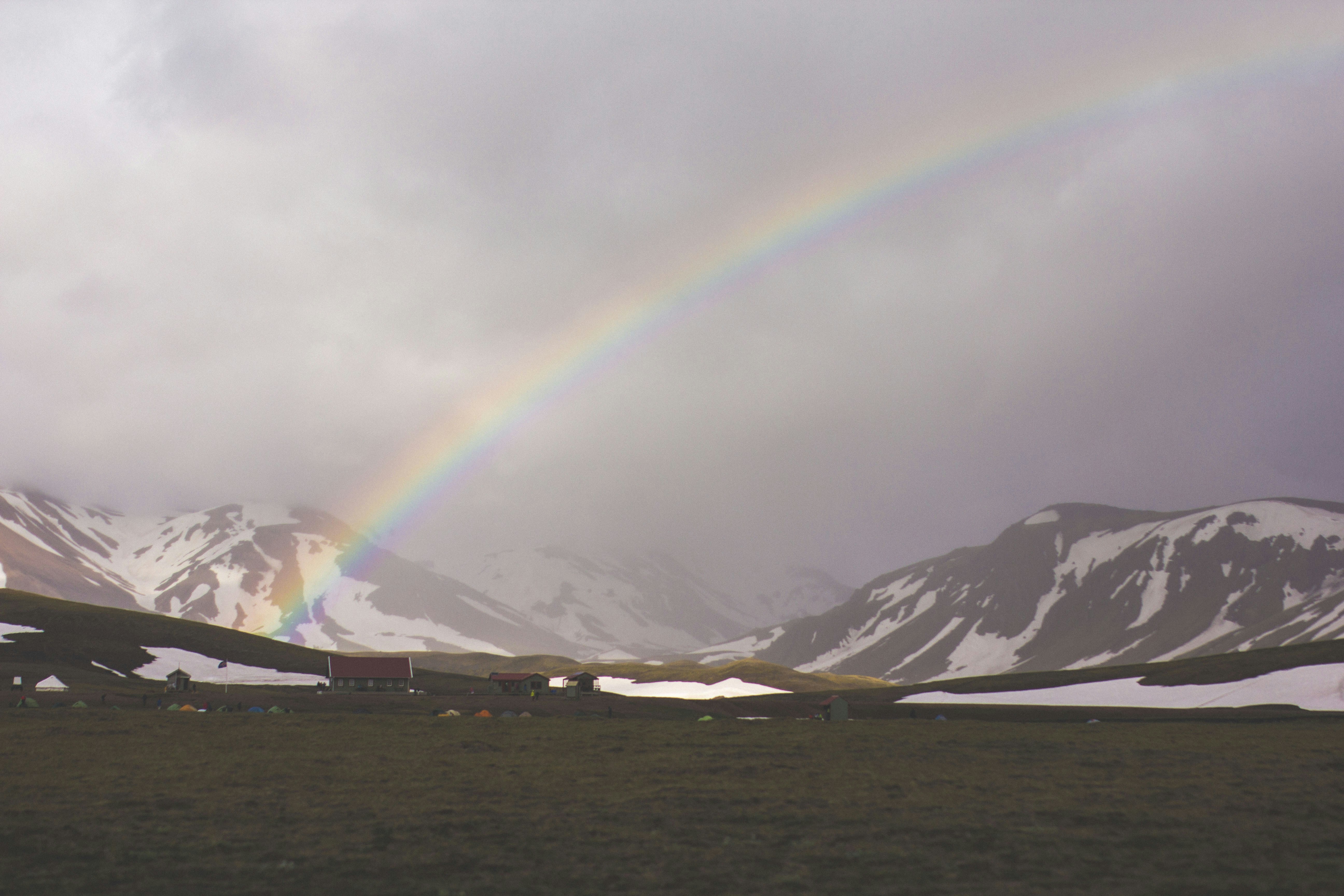 Rainbow Over Snow-capped Mountains
