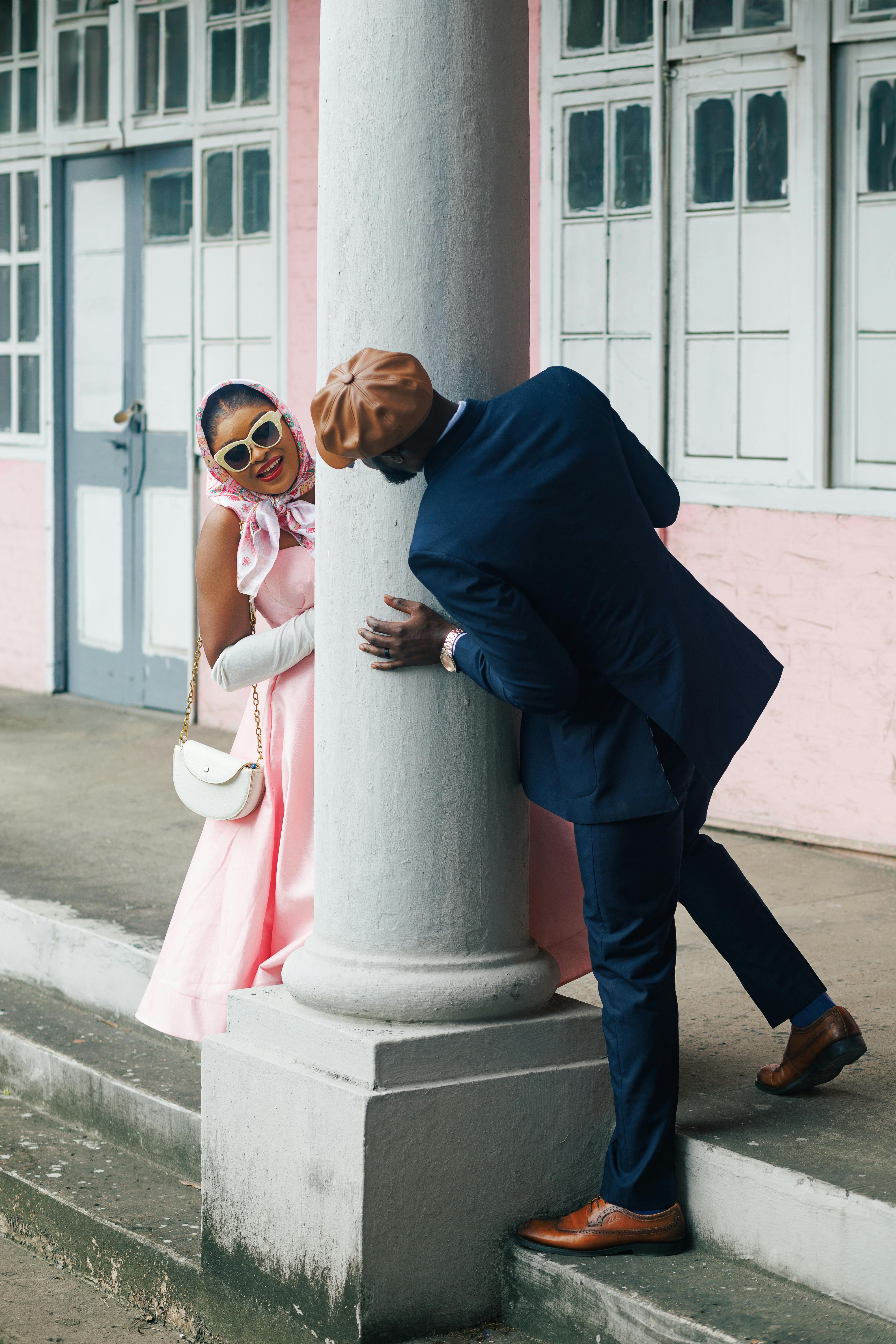 Playful Couple Peeking From Behind Column