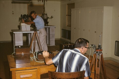 Two researchers with vintage scientific equipment