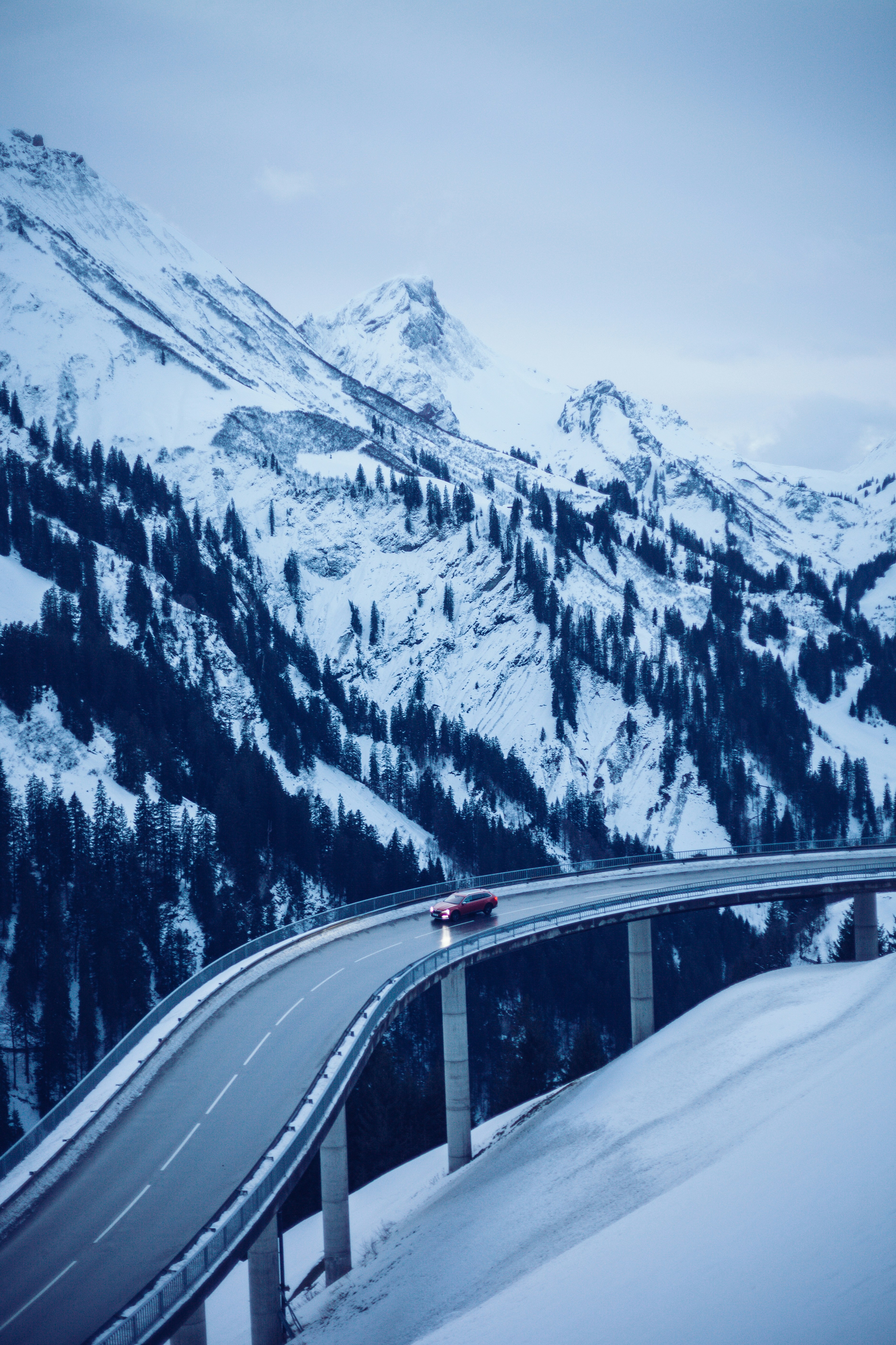 Red Car on Snowy Mountain Viaduct