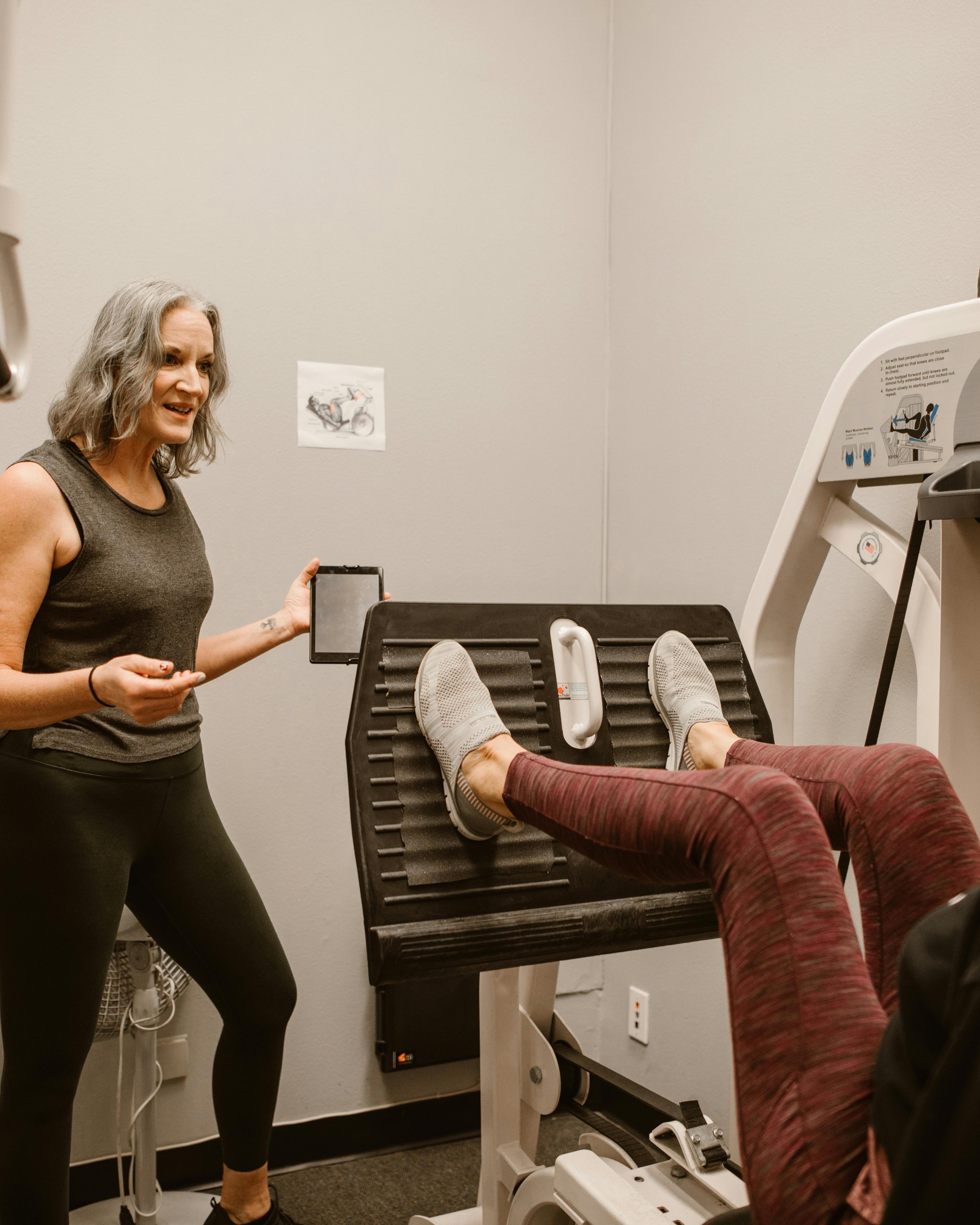 Trainer Guiding Client on Leg Press