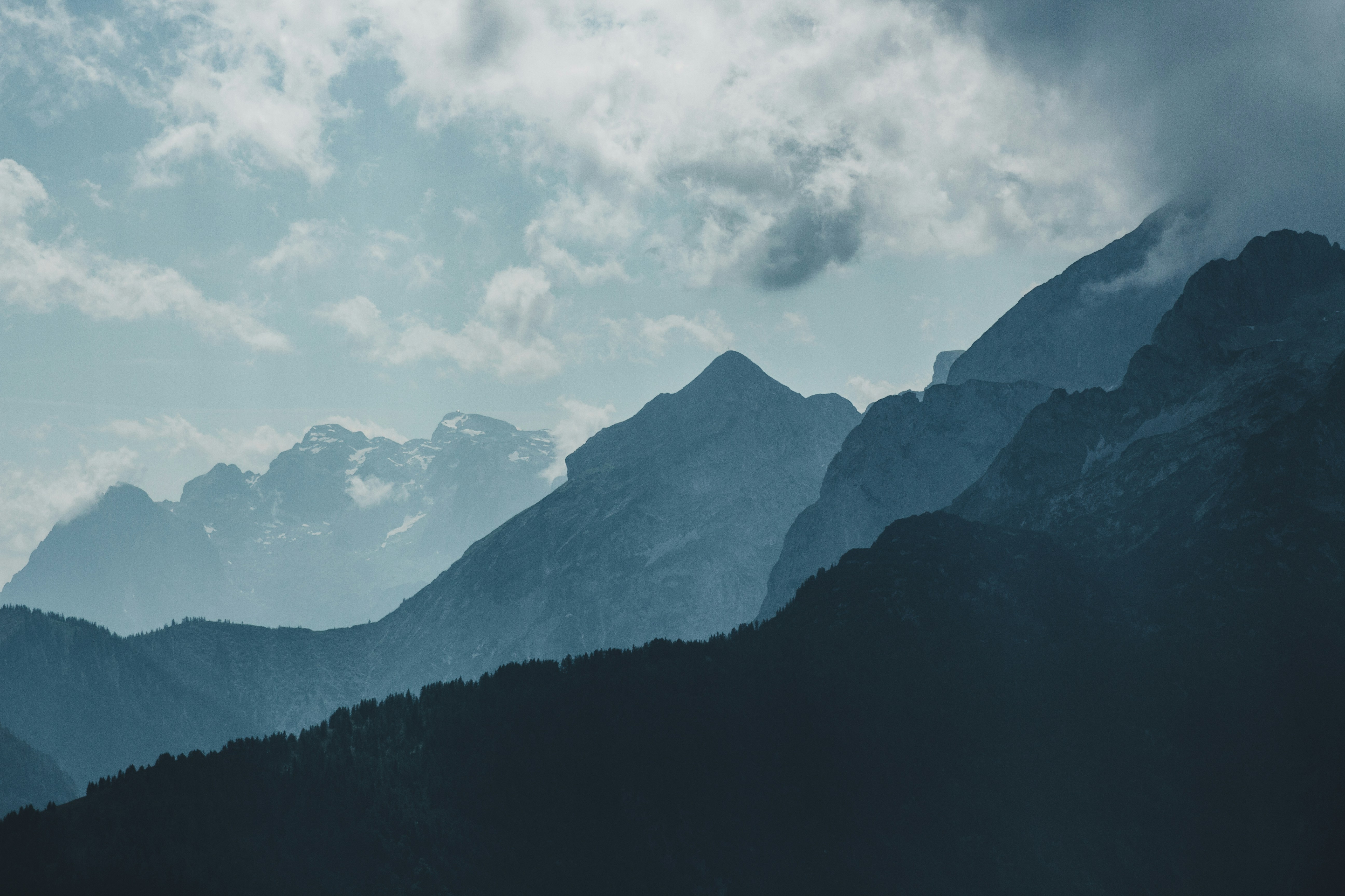 Layered Mountain Ranges Under Cloudy Sky