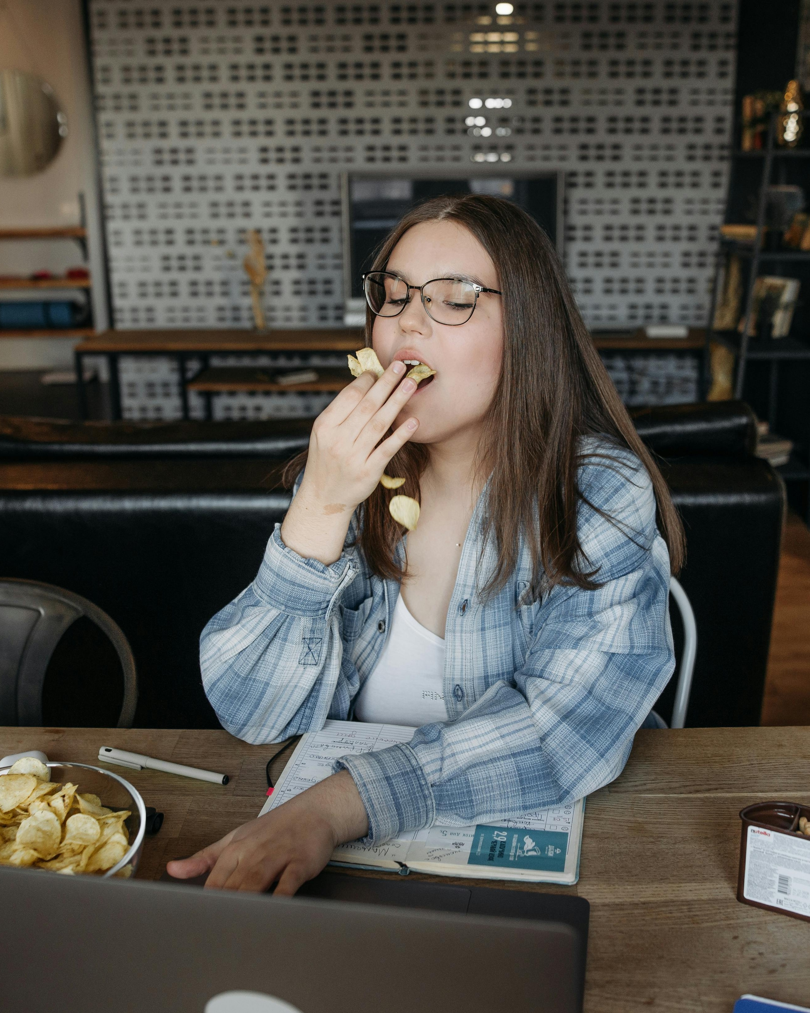Young Woman Eating Chips While Working From Home