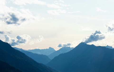 Layered Mountain Range Under Cloudy Sky