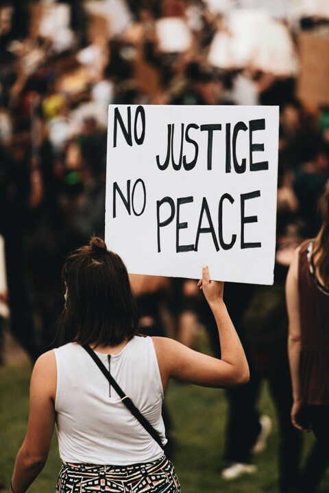 Protestor Holding No Justice No Peace Sign