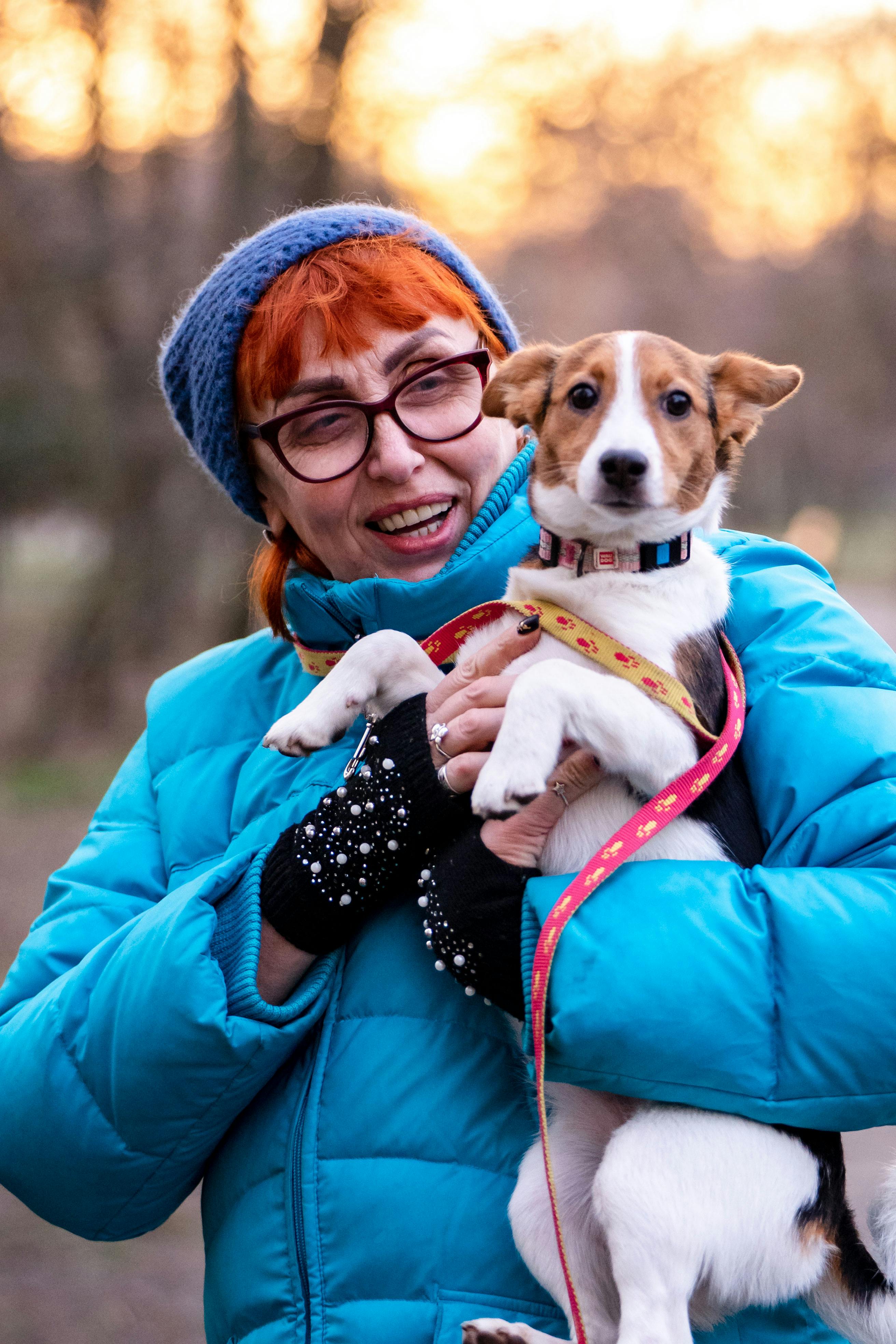 Woman Holding a Small Dog Outdoors