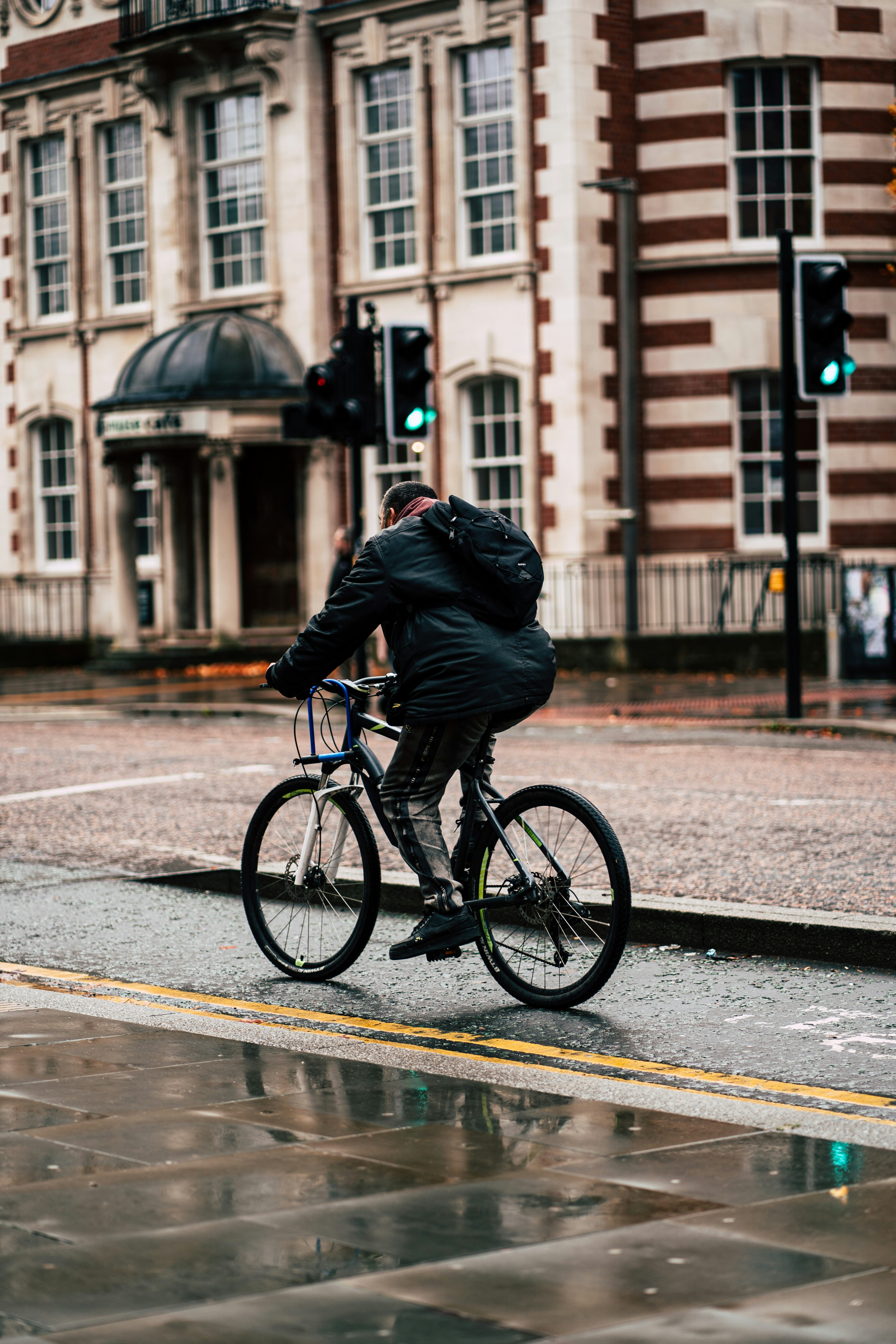 Cyclist Riding on Wet City Street