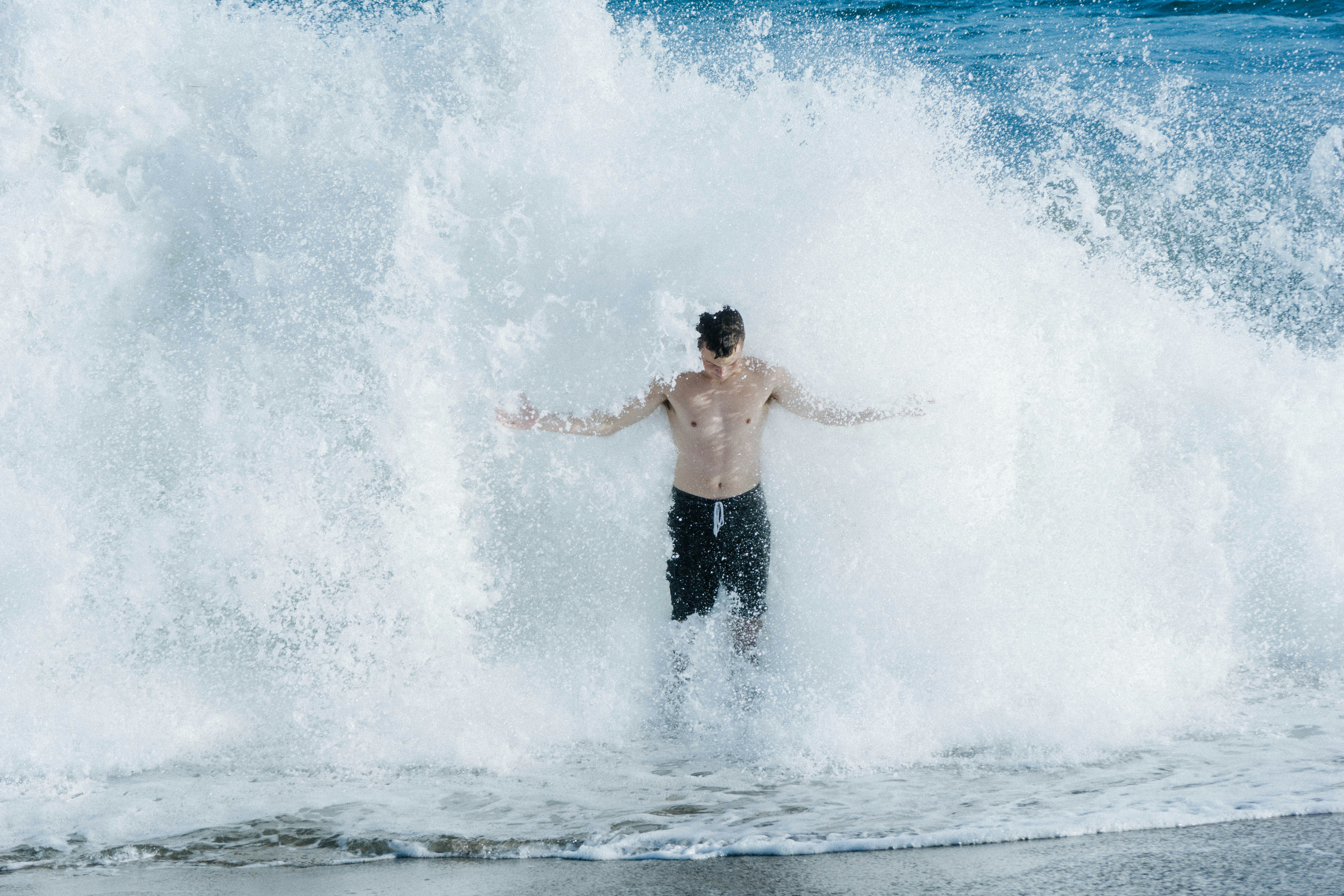 Man Standing In Crashing Ocean Wave