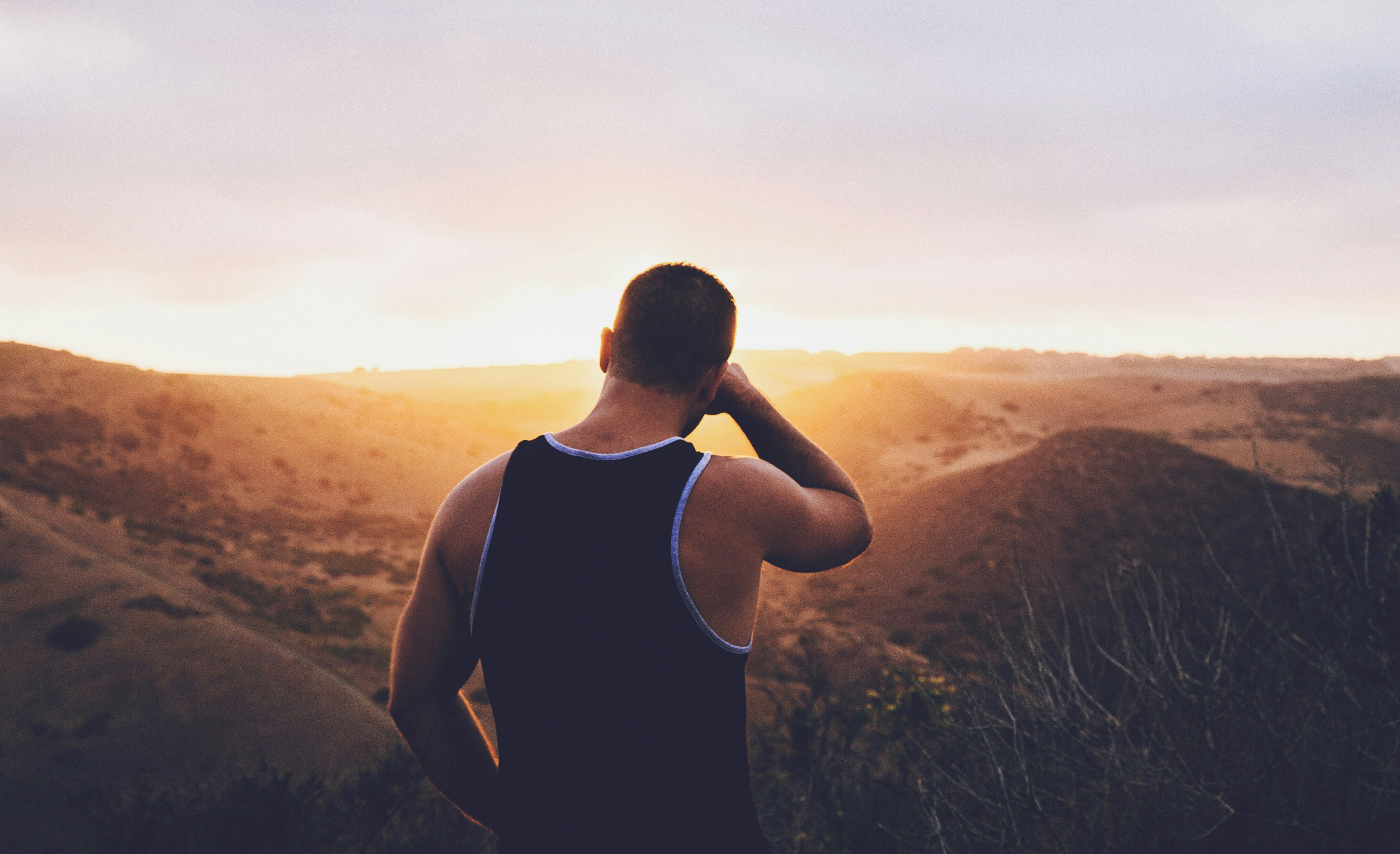 Man Viewing Sunset Over Hills