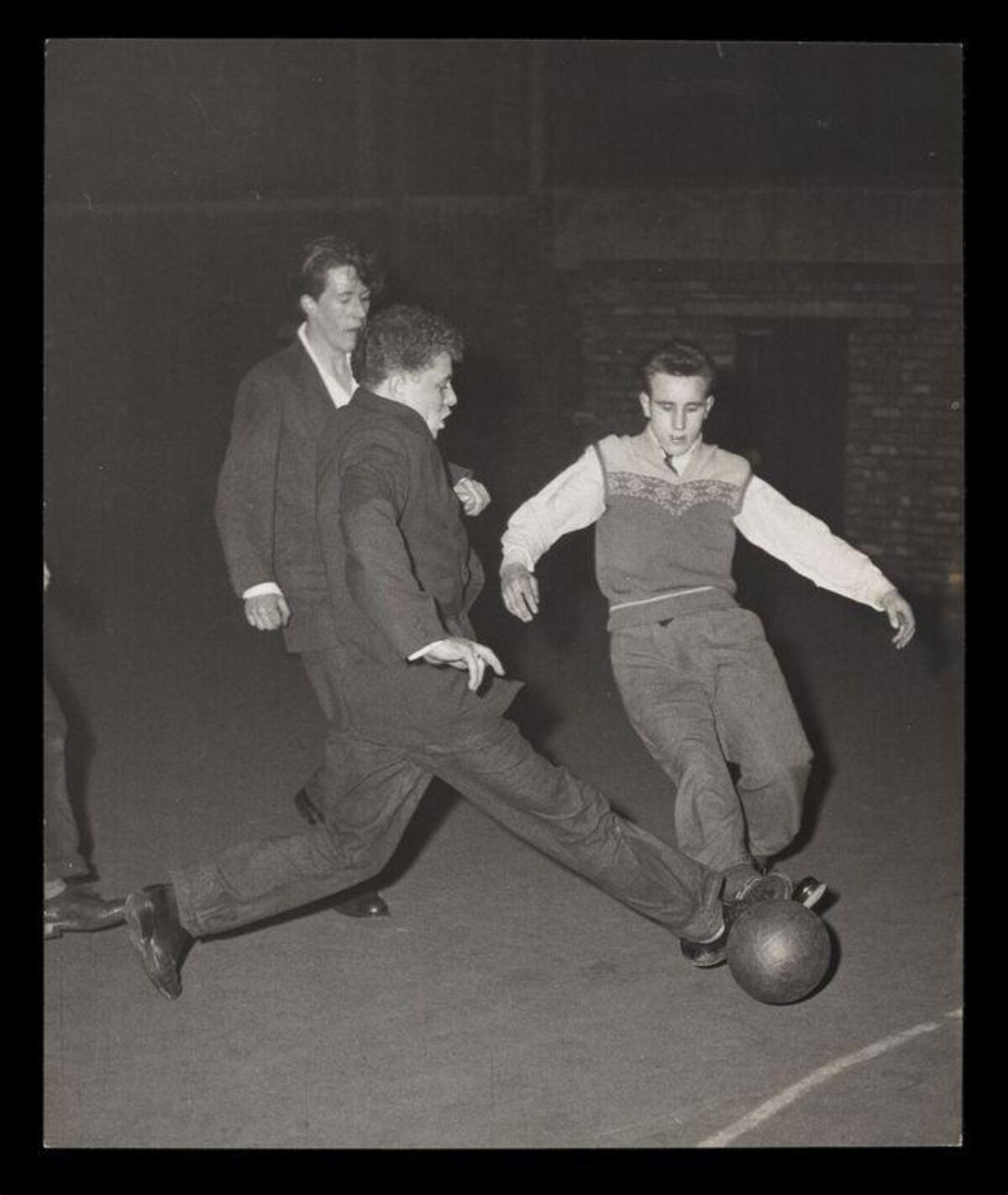 Three Young Men Playing Football
